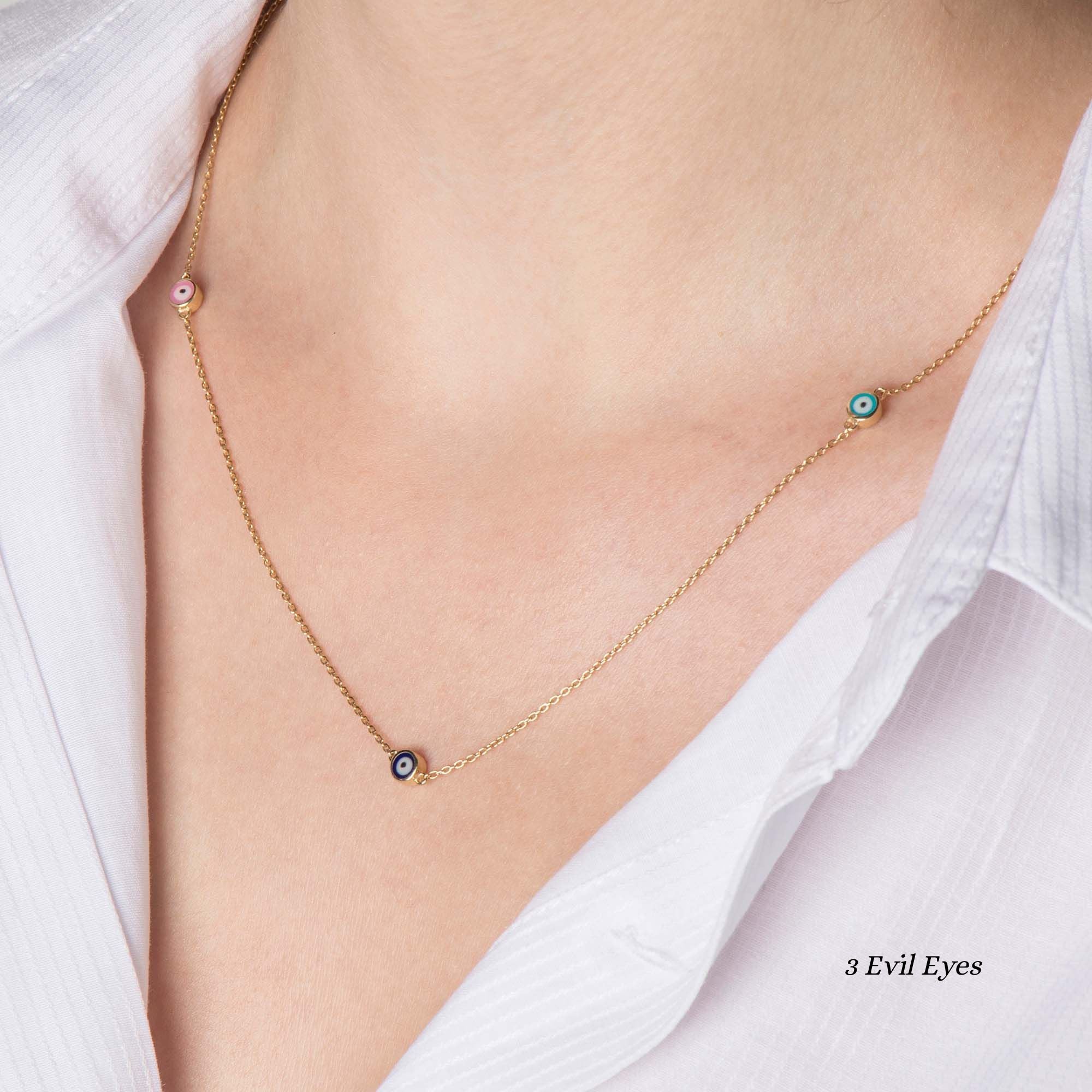 Close up of a model wearing a 3 multicolor evil eye station necklace.