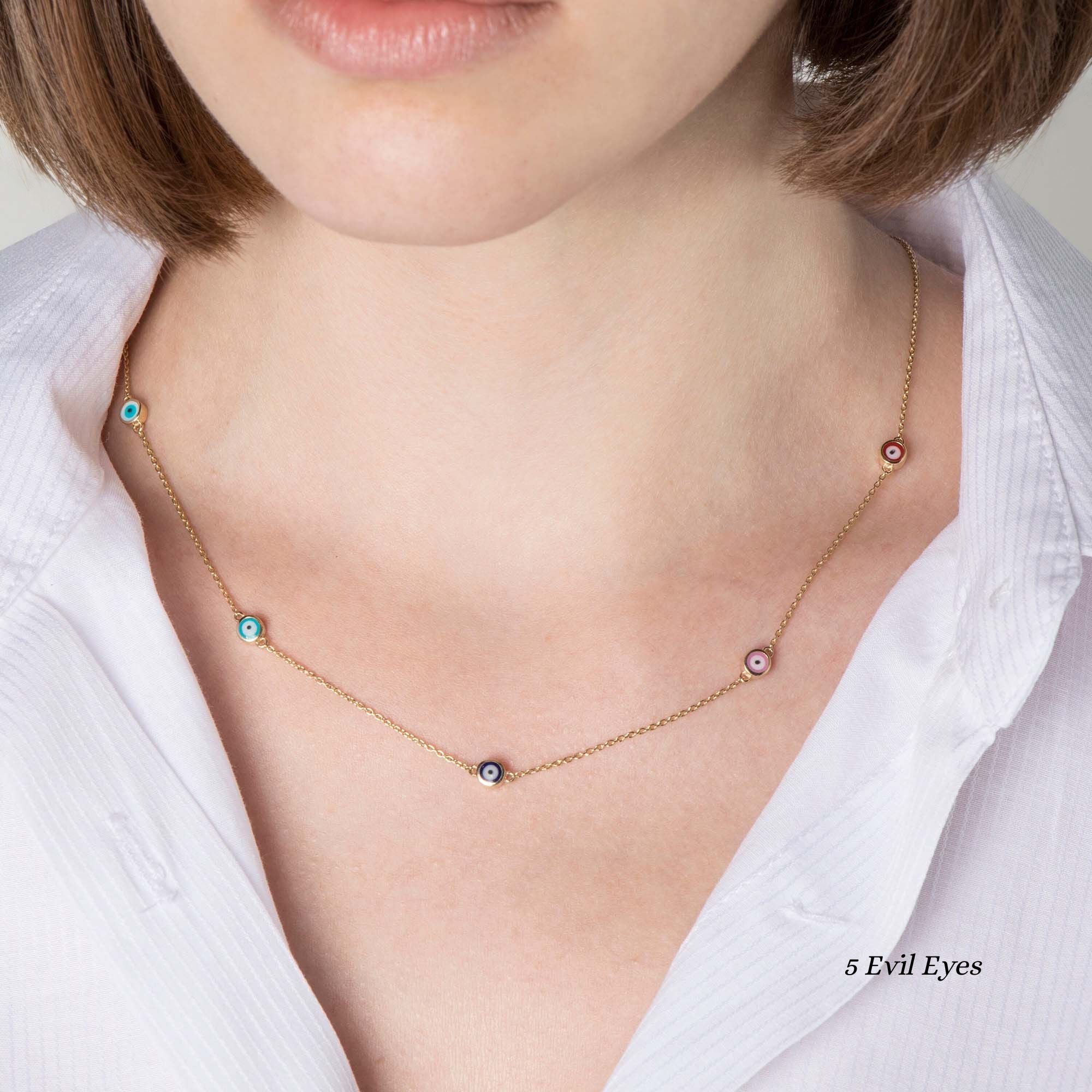 Close up of a model wearing a 5 multicolor evil eye station necklace.