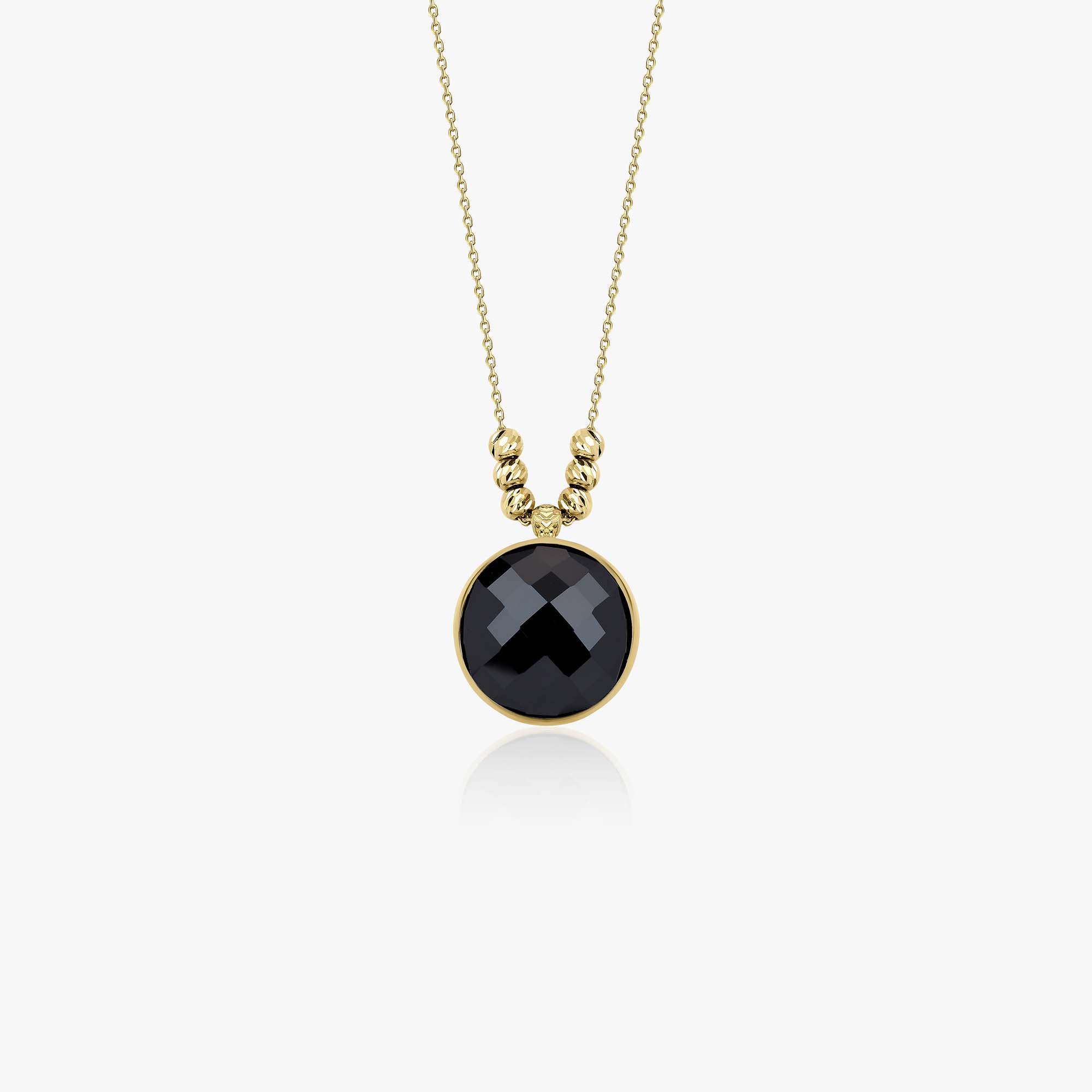 Gold necklace with a black crystal pendant on a white background
