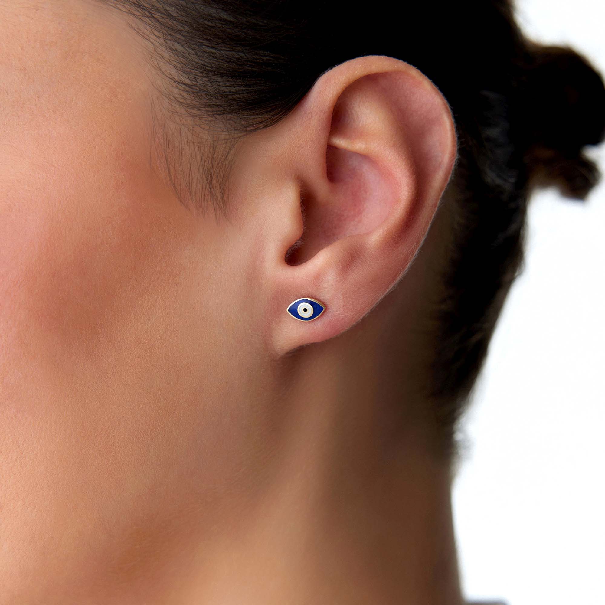 A model wearing a navy blue evil eye stud