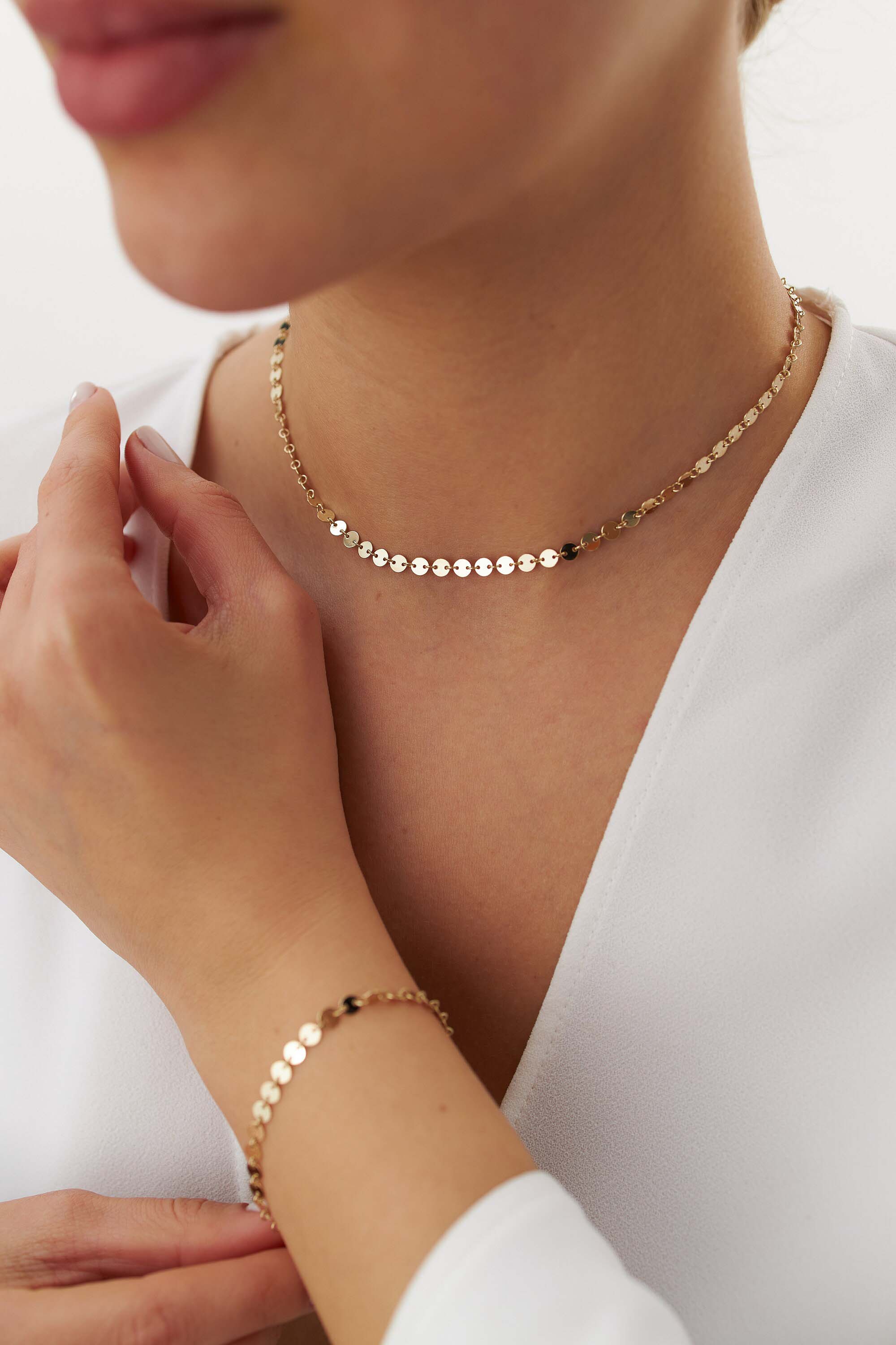 14k yellow gold circle chain necklace worn by a person with a plain background