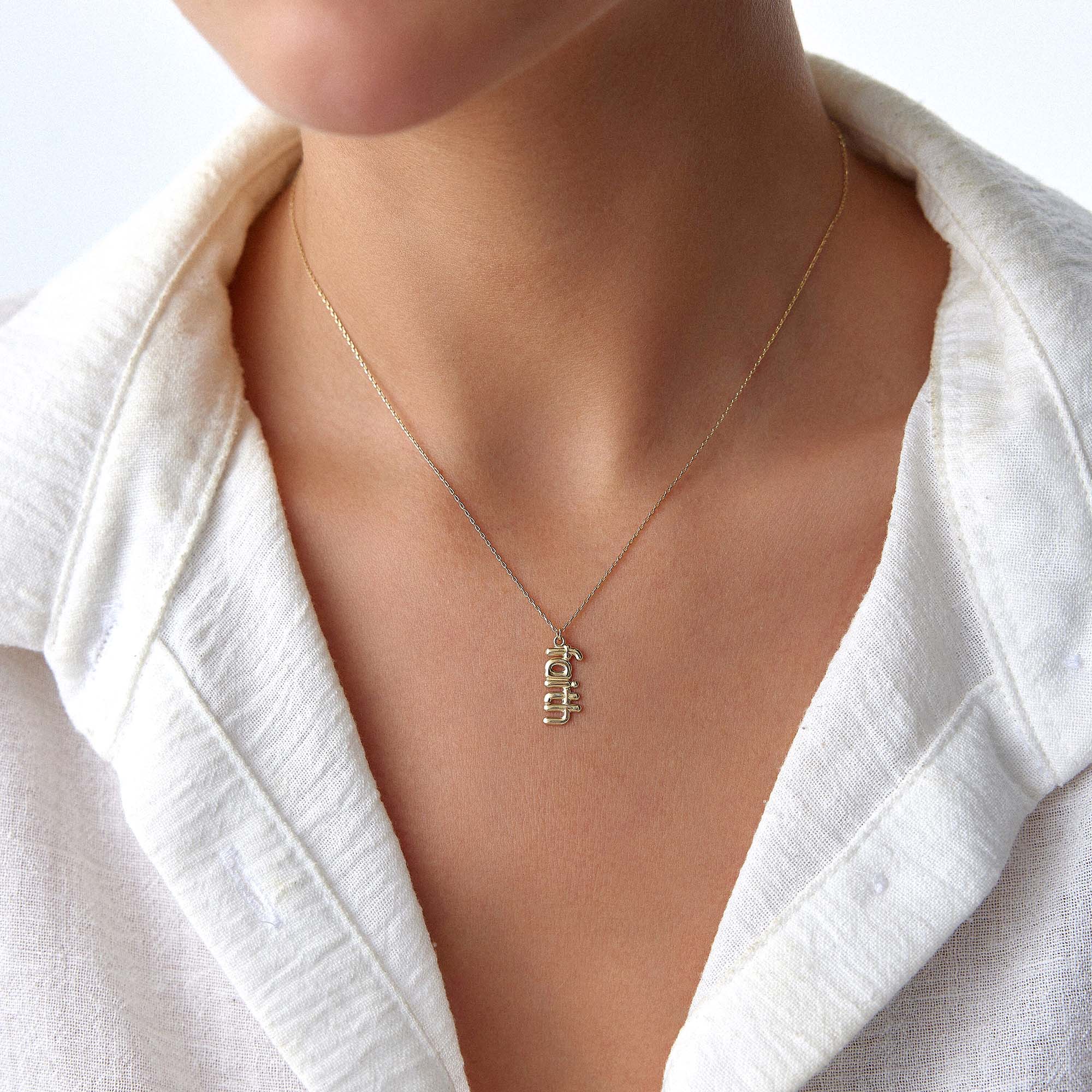 A model wearing a 14k yellow gold faith necklace.