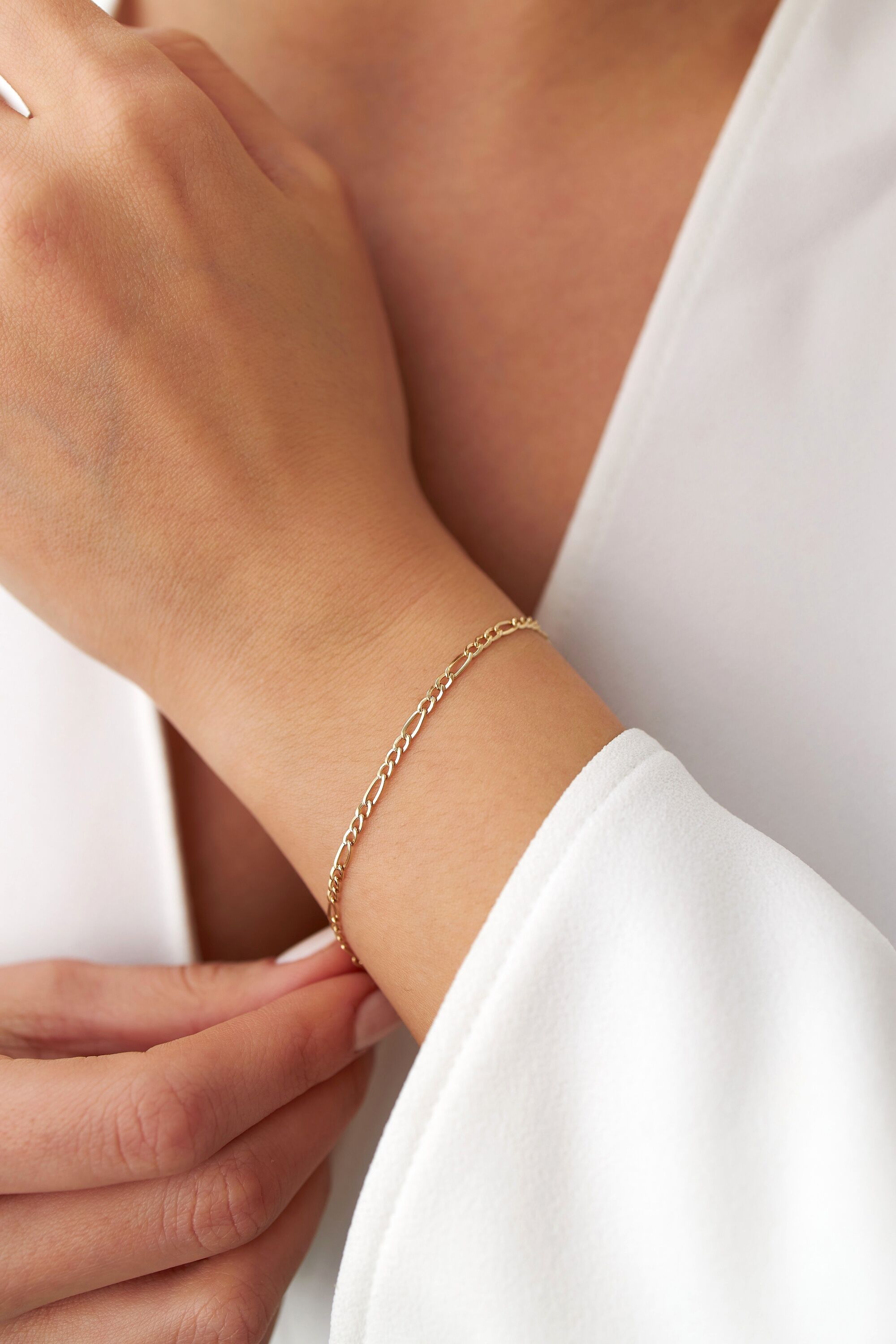 A minimal figaro chain on a models wrist from far away