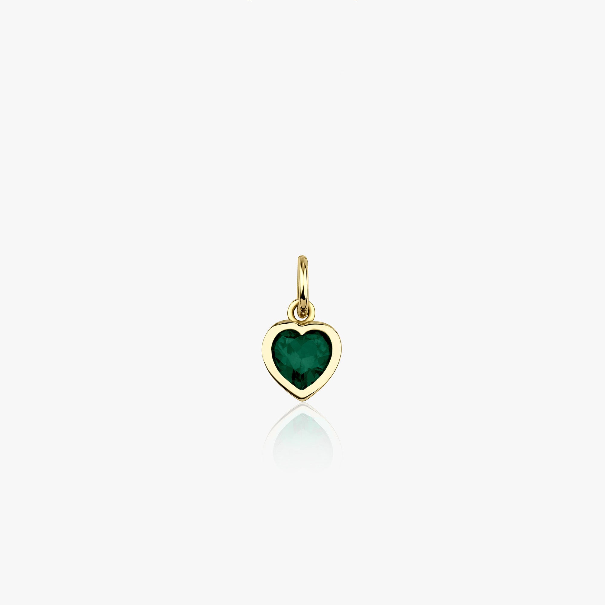 A 14k yellow gold heart pendant with a green heart cut zirconia center