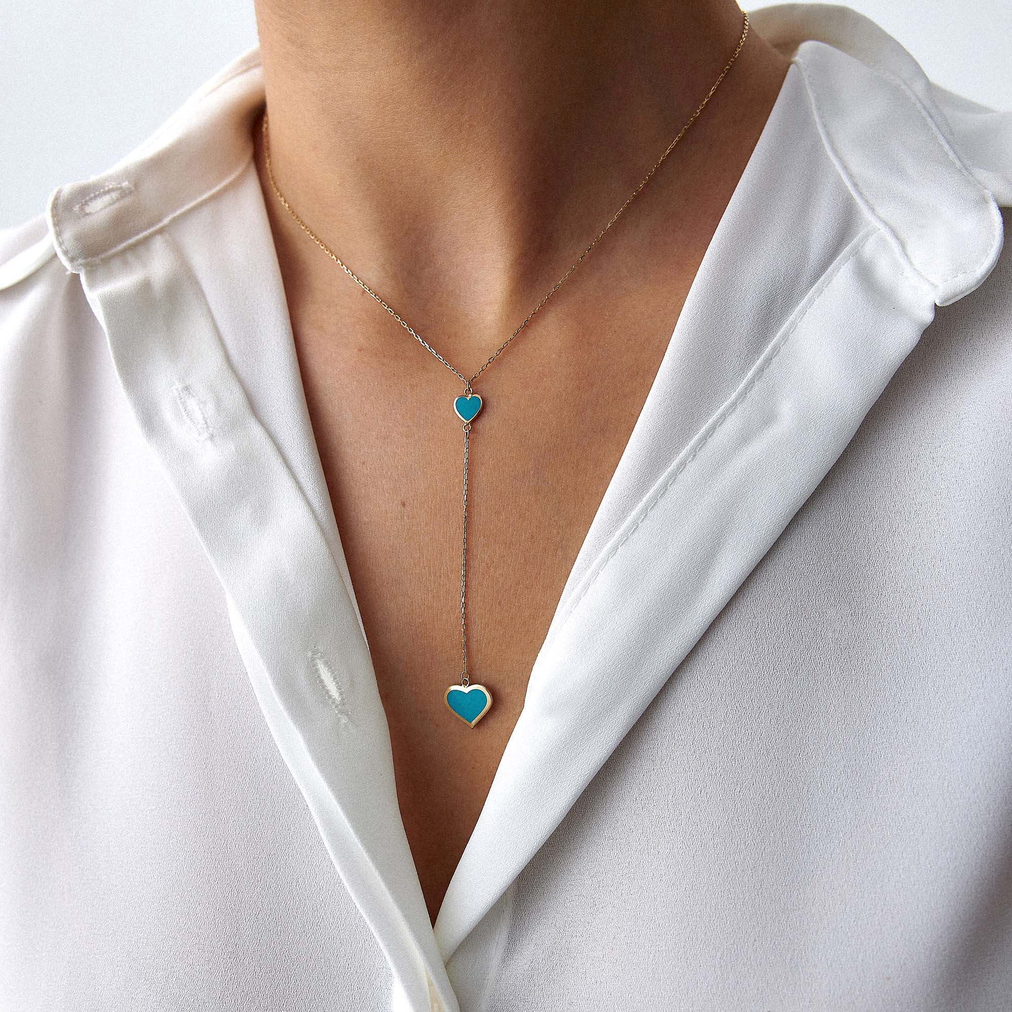 A model wearing a 14k yellow gold heart lariat necklace