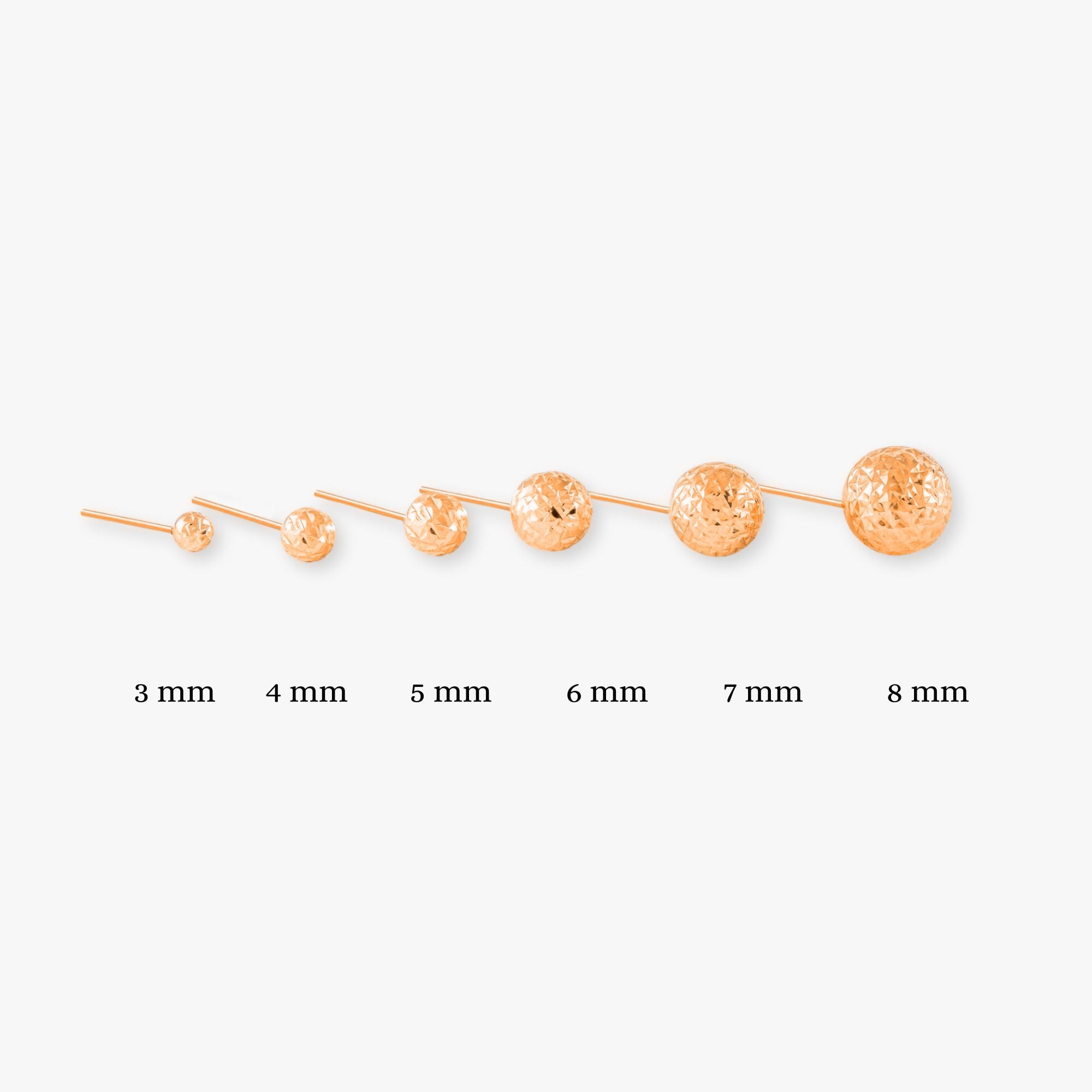 A selection of single 14k rose gold laser cut sphere studs in various sizes, displayed in a row with their corresponding sizes labeled, on a white background.