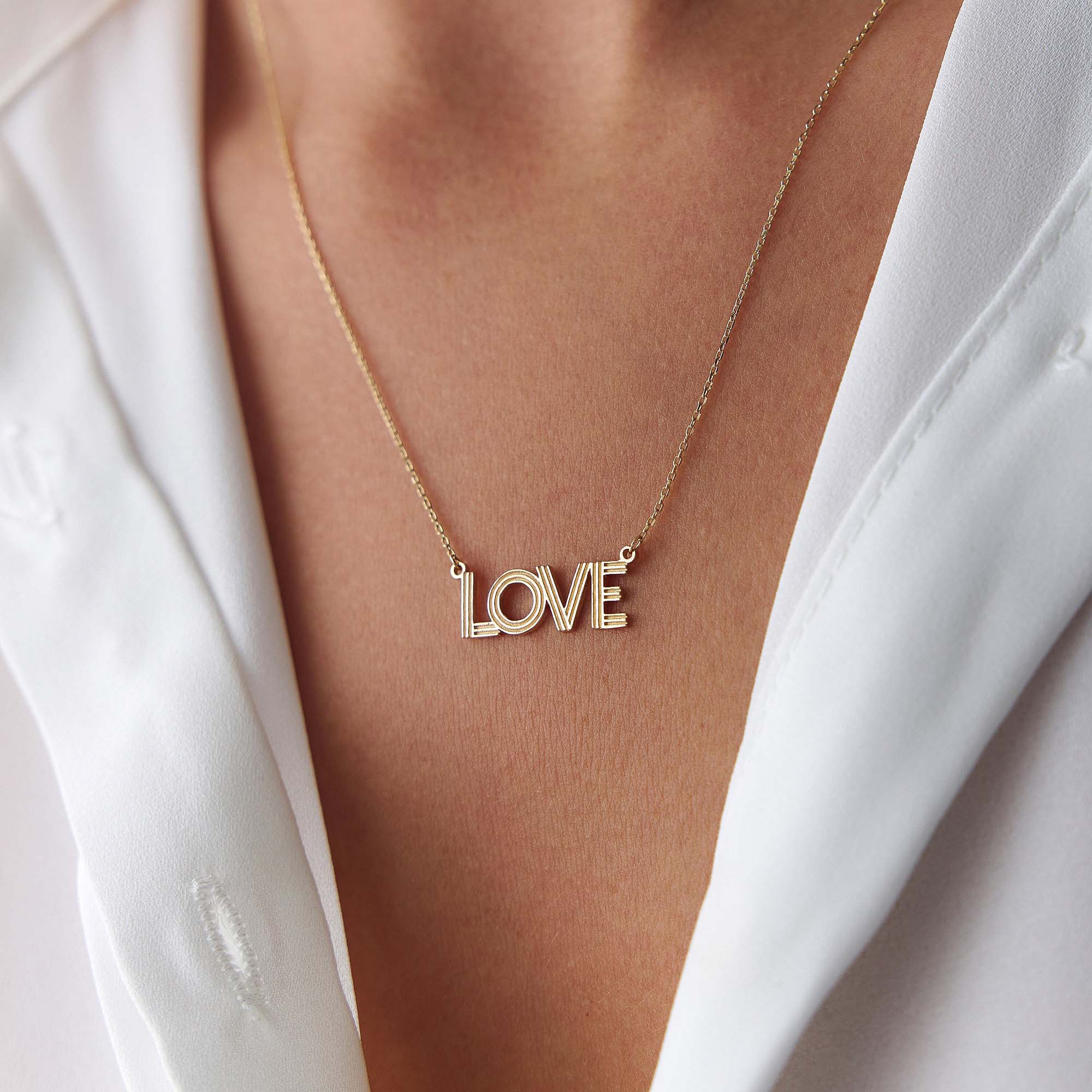 14k yellow gold love necklace worn by a model
