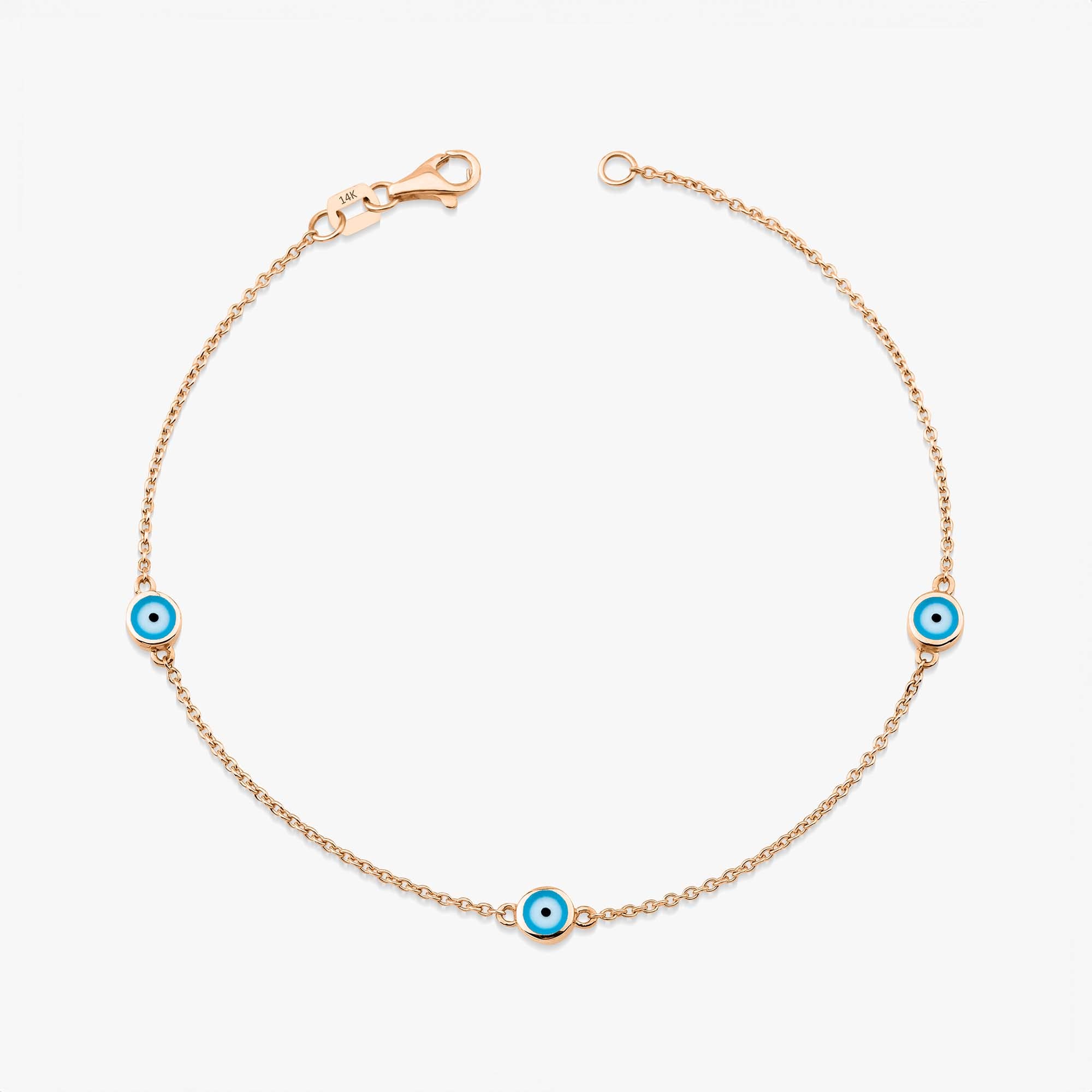 A 14K rose gold bracelet with three ocean blue enamel evil eyes, designed for daily wear.