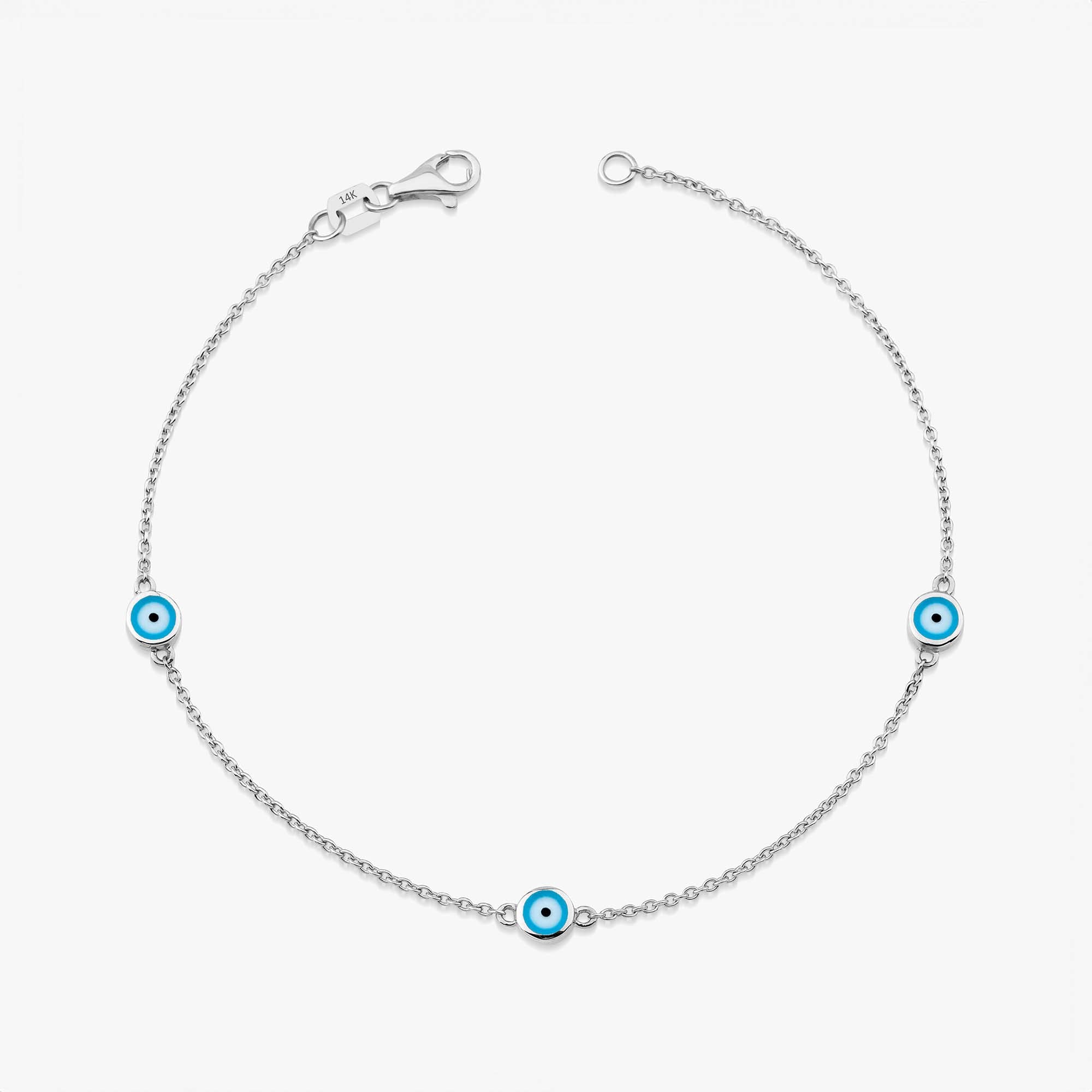 A 14K white gold bracelet with three ocean blue enamel evil eyes, designed for daily wear.