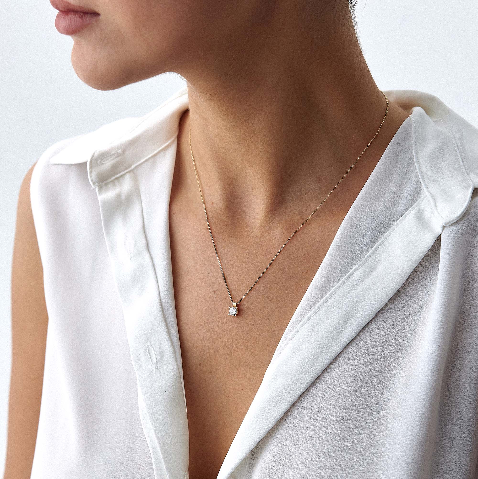 A model wearing a solitaire necklace.