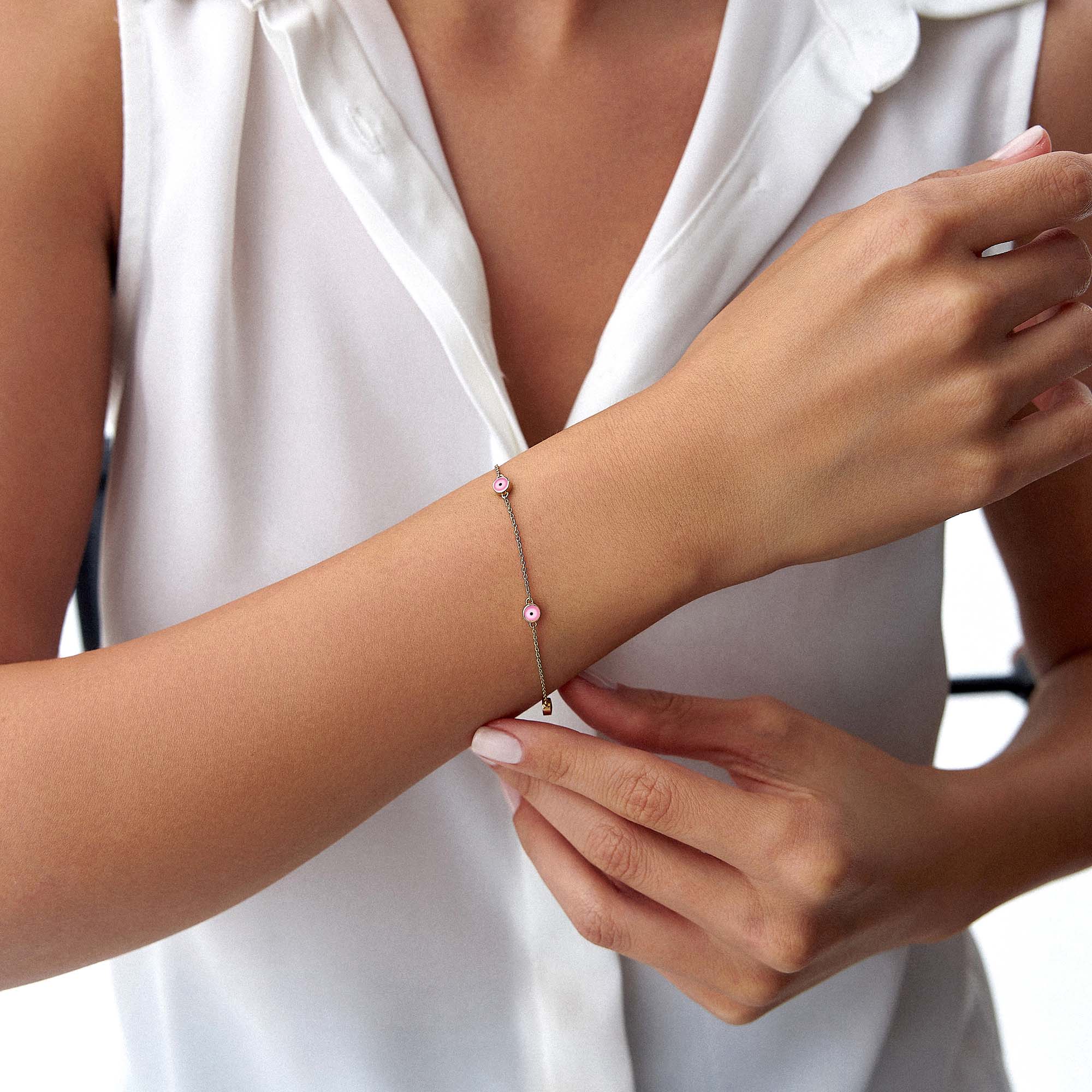 14k yellow gold pink evil eye bracelet with 5 evil eyes on a wrist