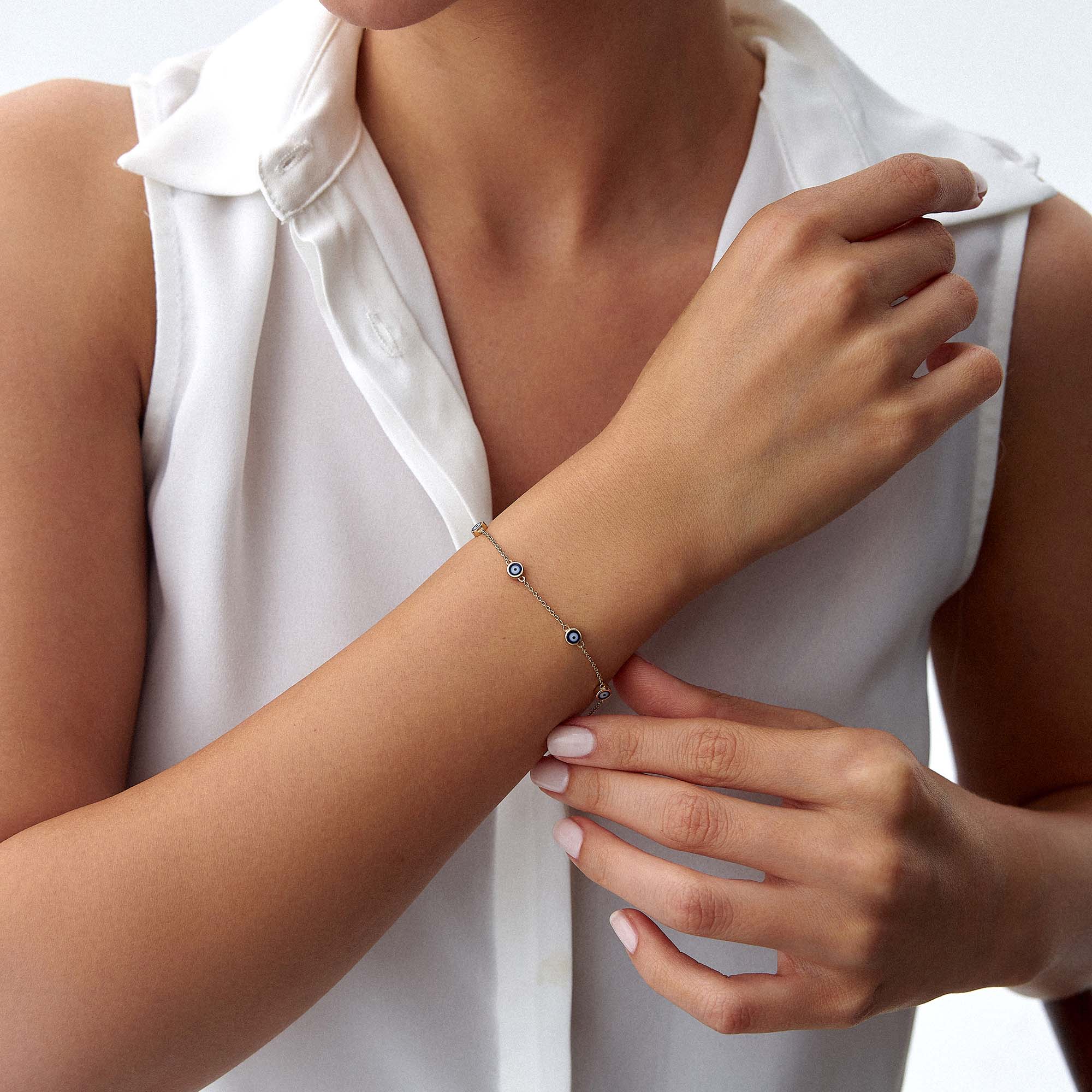 14k yellow gold navy blue evil eye bracelet with 7 evil eyes shown on a wrist