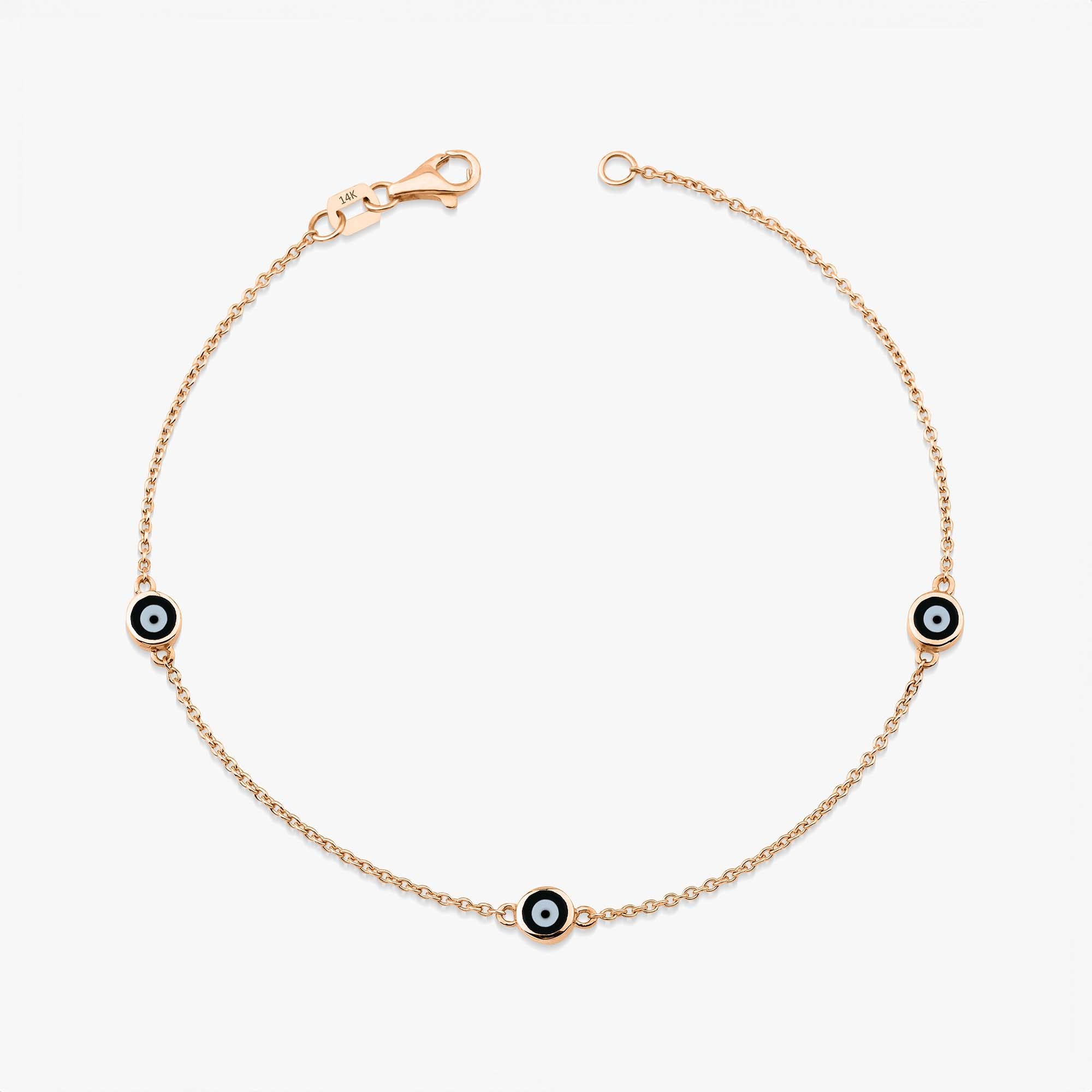 14 karat yellow gold three black evil eye bracelet with lobster clasp on a white background