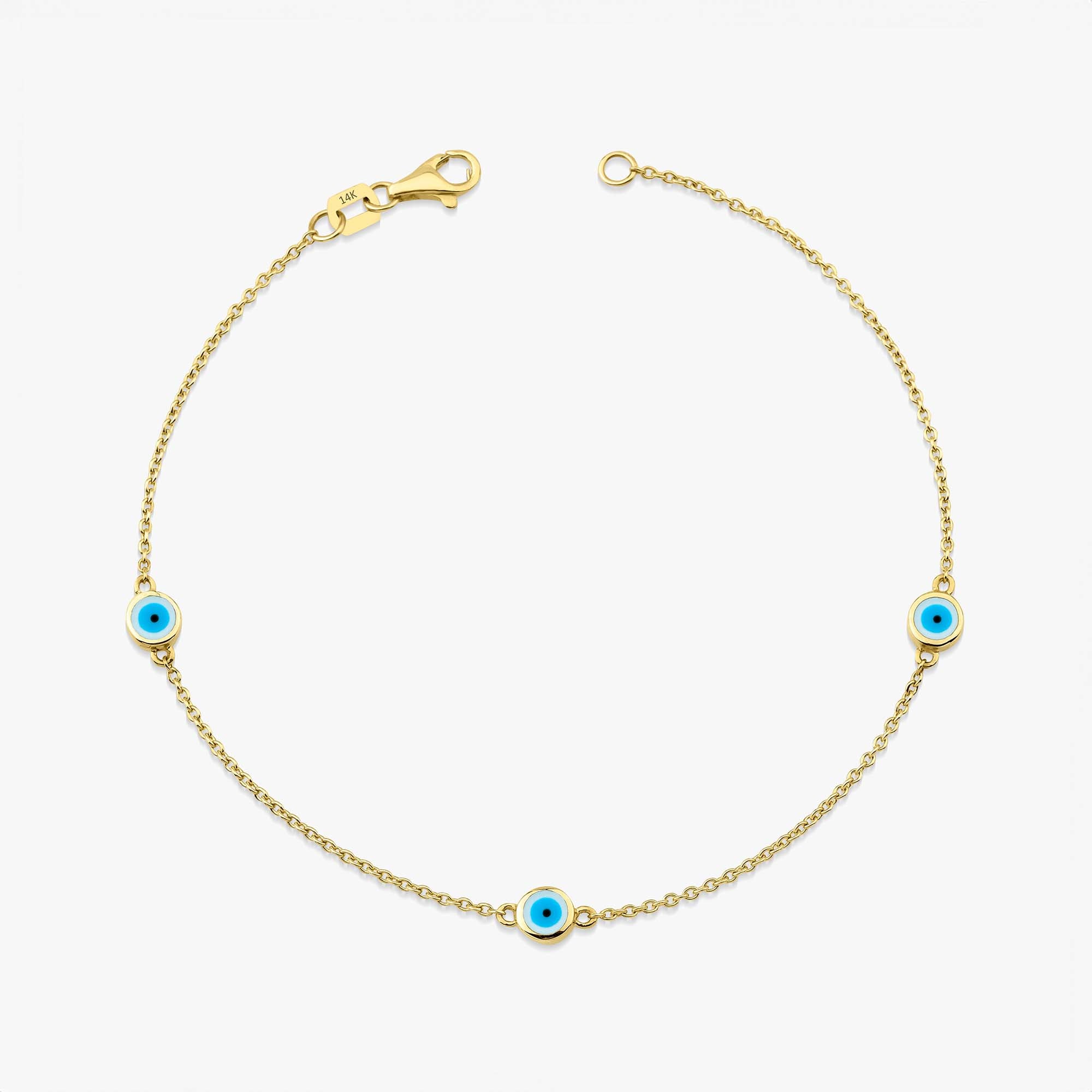 A 14 karat yellow gold bracelet with three white evil eye charms on a white background