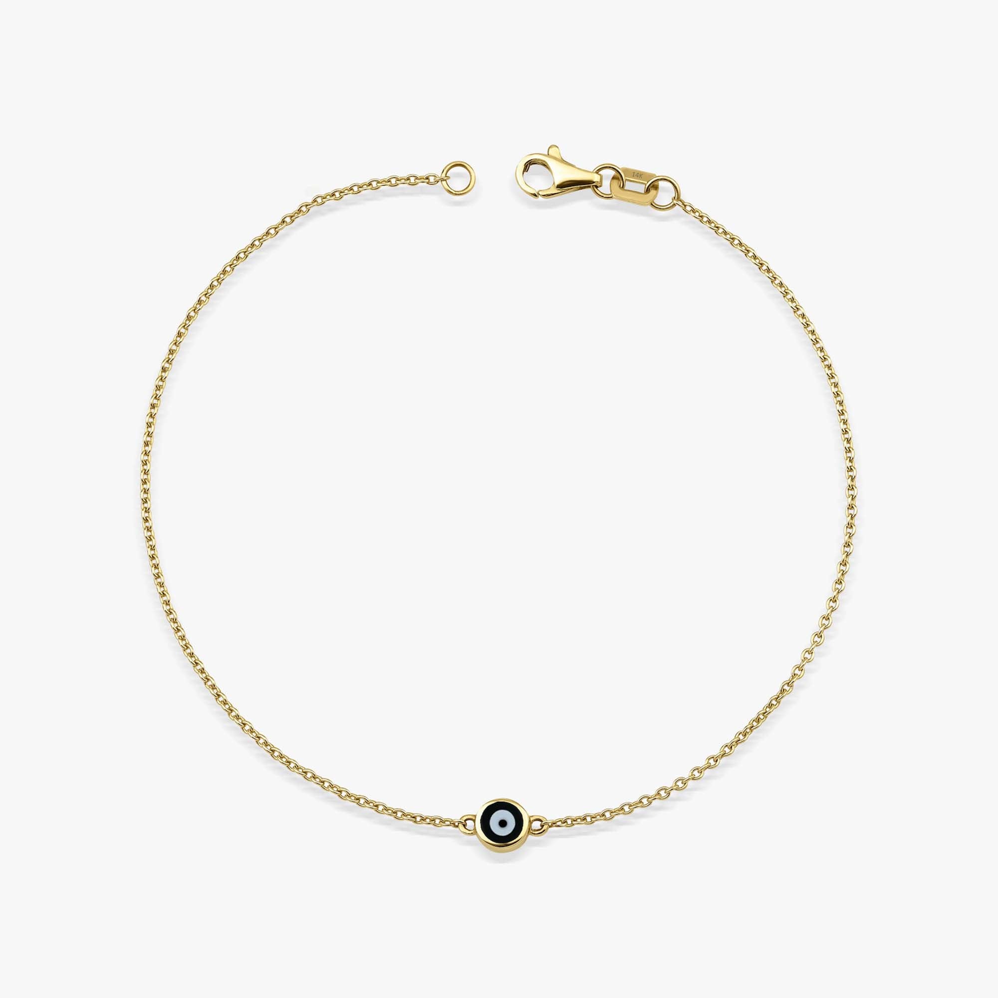 A 14K solid yellow gold evil eye bracelet with a minimal black enamel design on a white background.