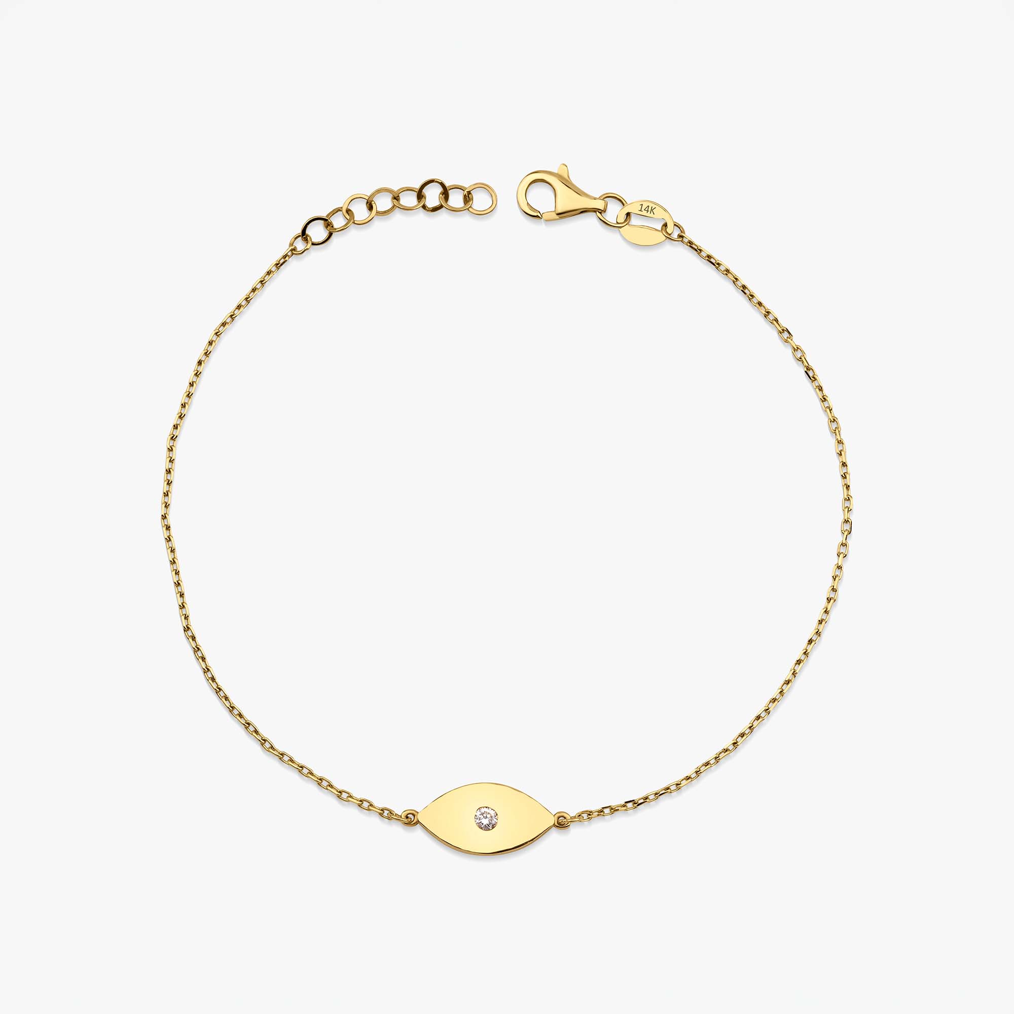 A delicate gold chain bracelet with a small oval eye charm set with a tiny clear stone, displayed on a clean white background.