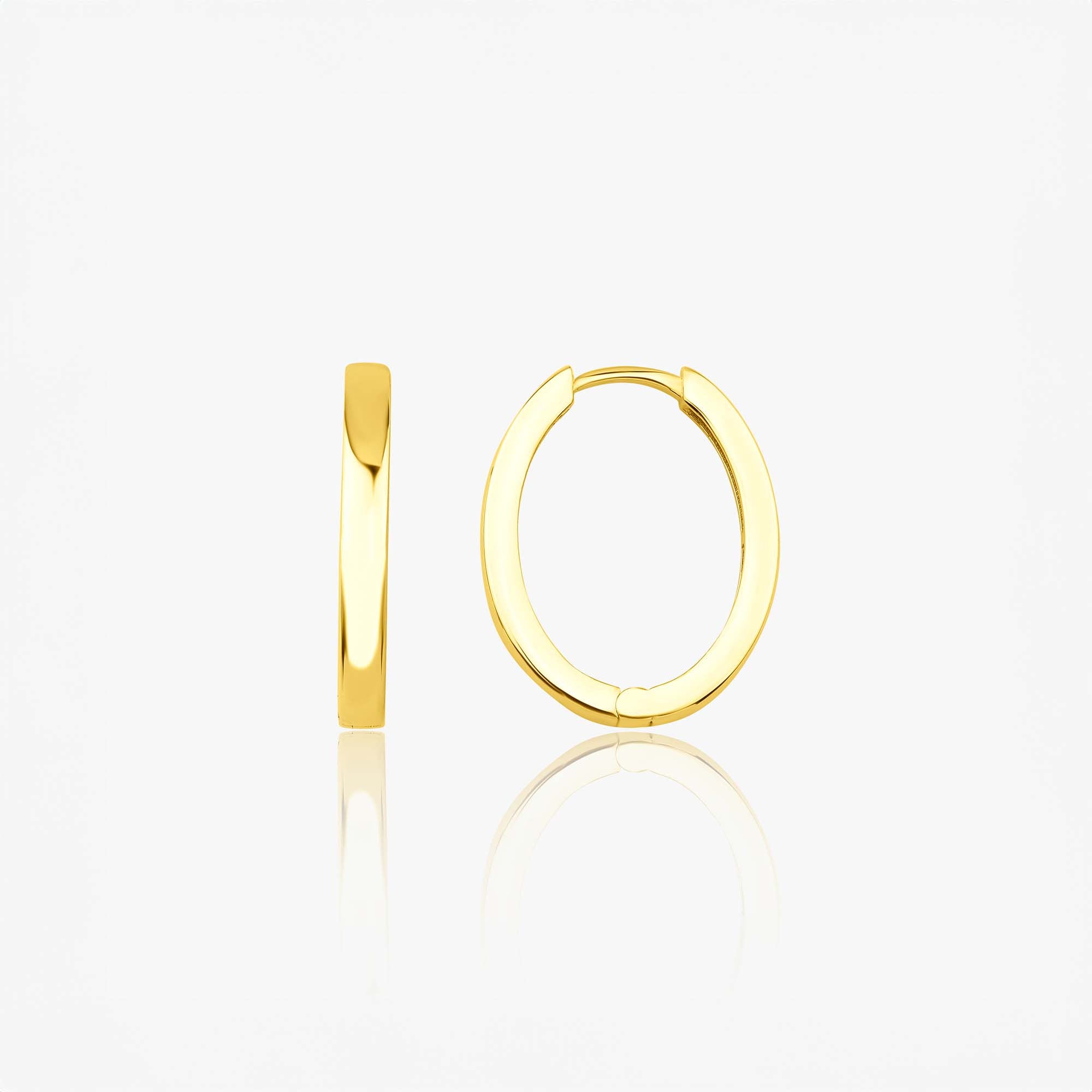A pair of 14k yellow gold oval shaped hoops shown sideways on a white background.