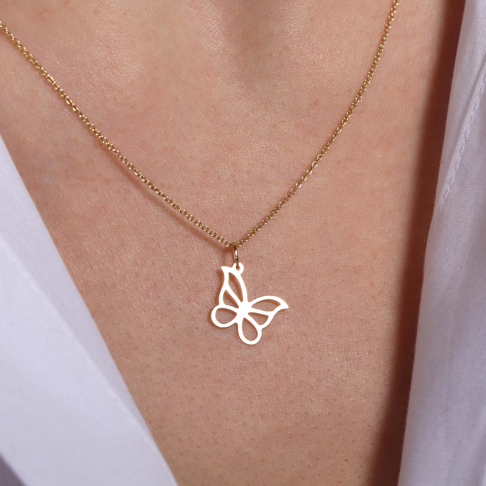 A model wearing a 14k yellow gold minimal butterfly pendant necklace