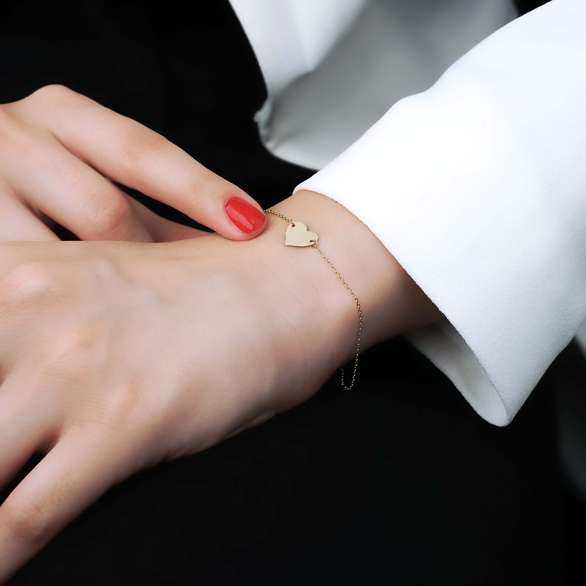 minimal heart bracelet shown on a models wrist
