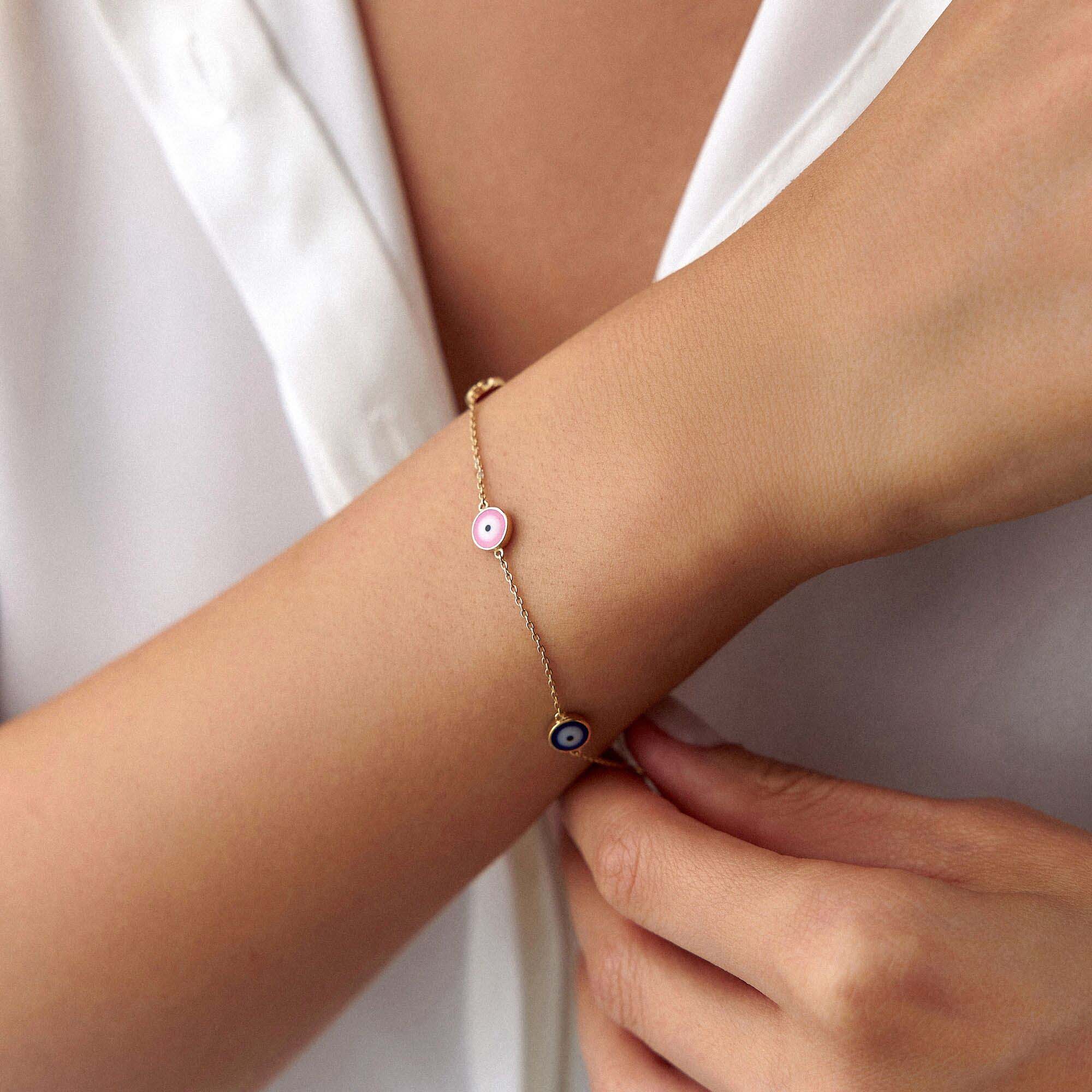 A 14K gold bracelet featuring multiple multicolored evil eye charms on a chain.
