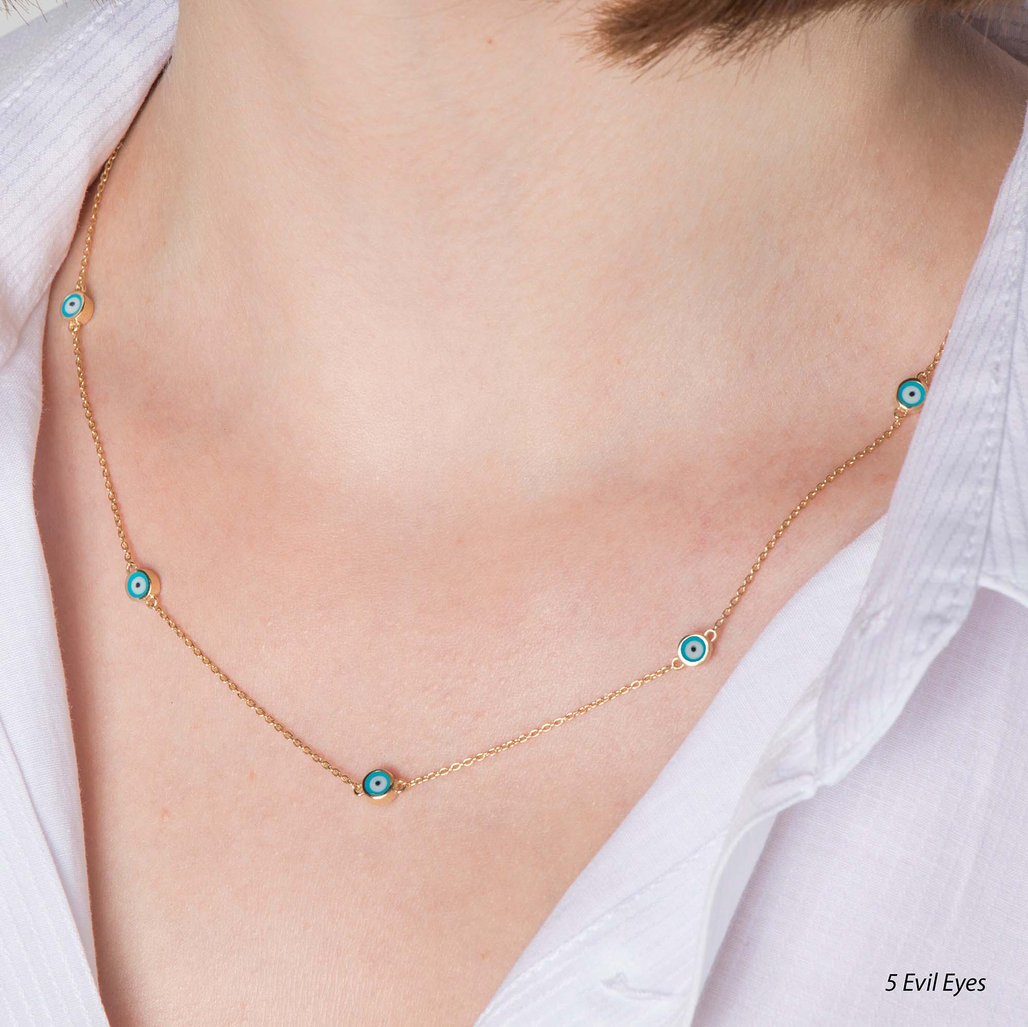 A model wearing an 5 evil eye station necklace with ocean blue evil eyes.