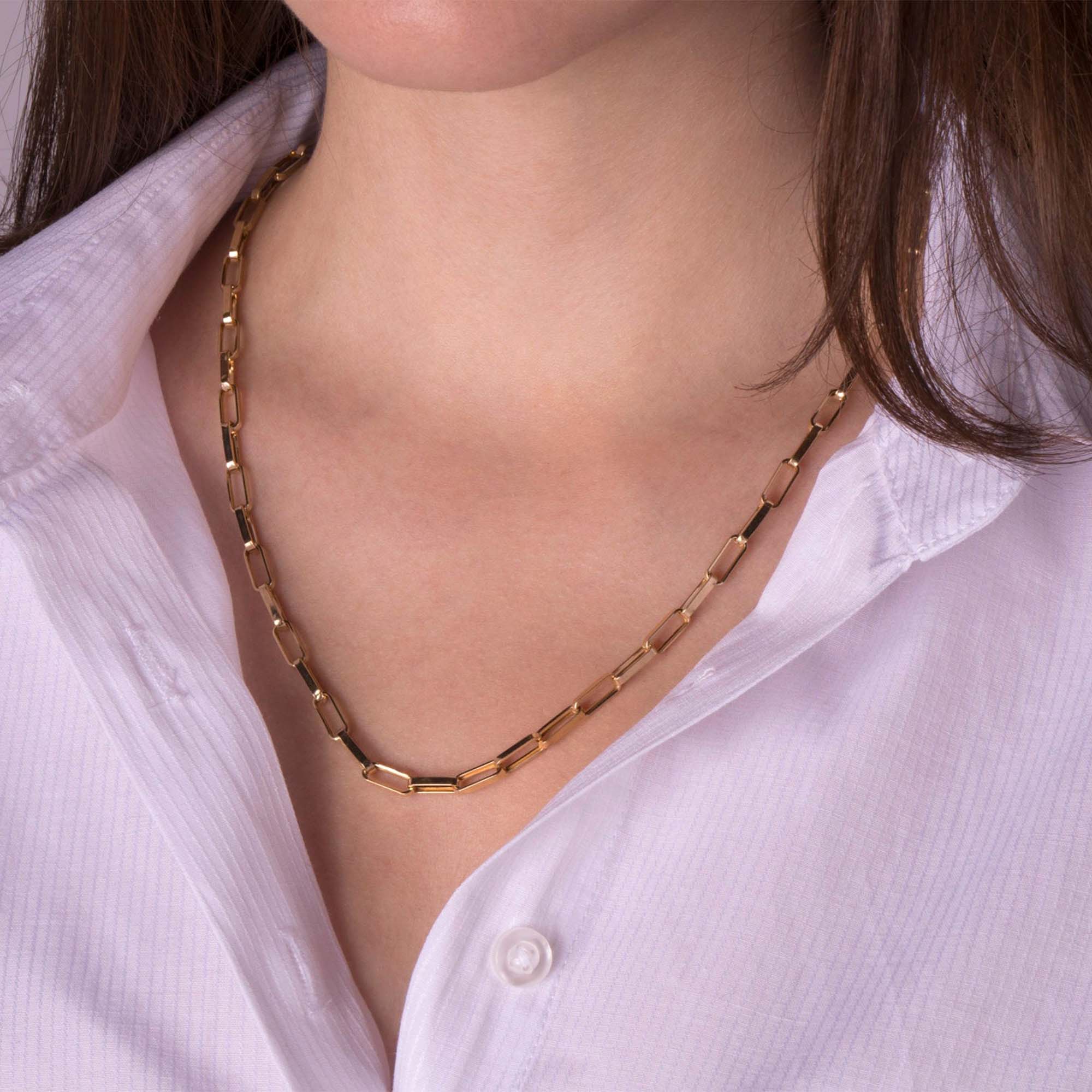 A model wearing a 14k yellow gold paperclip chain necklace.