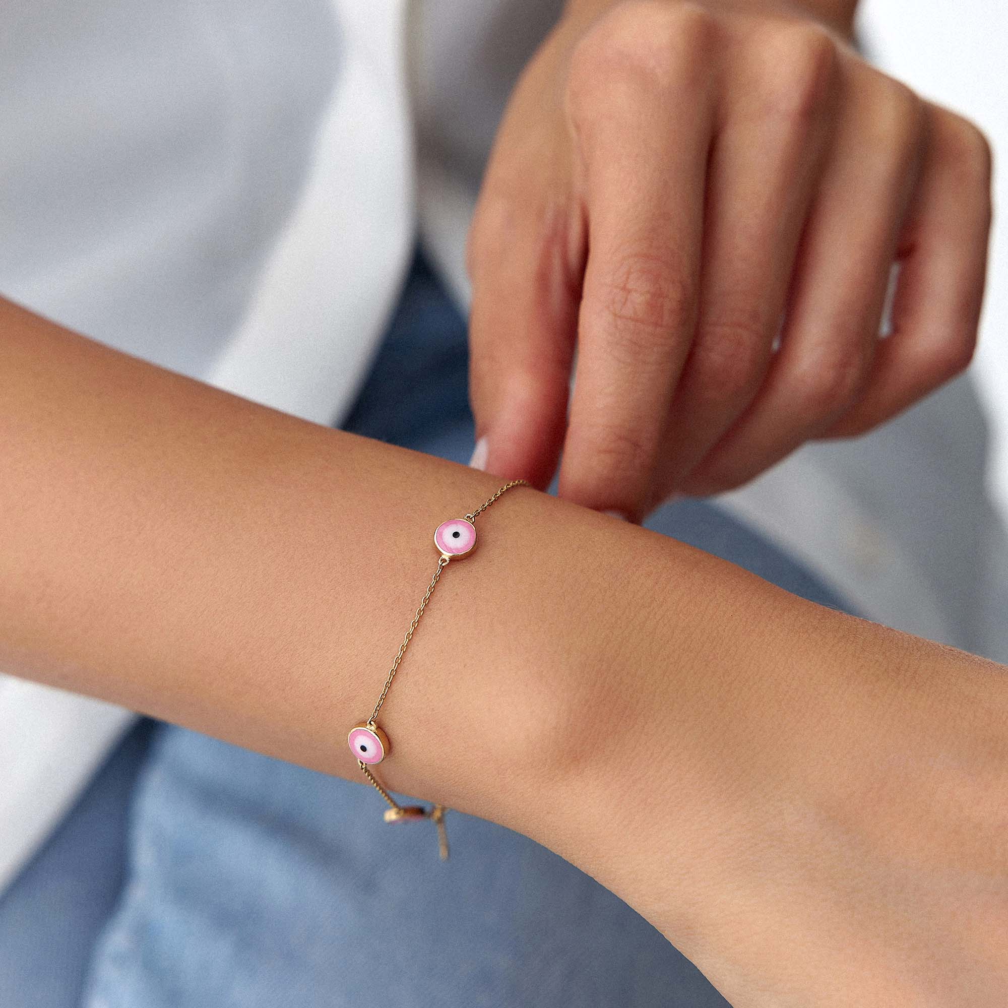14k yellow gold evil eye bracelet with 5 royal pink evil eyes shown on a wrist