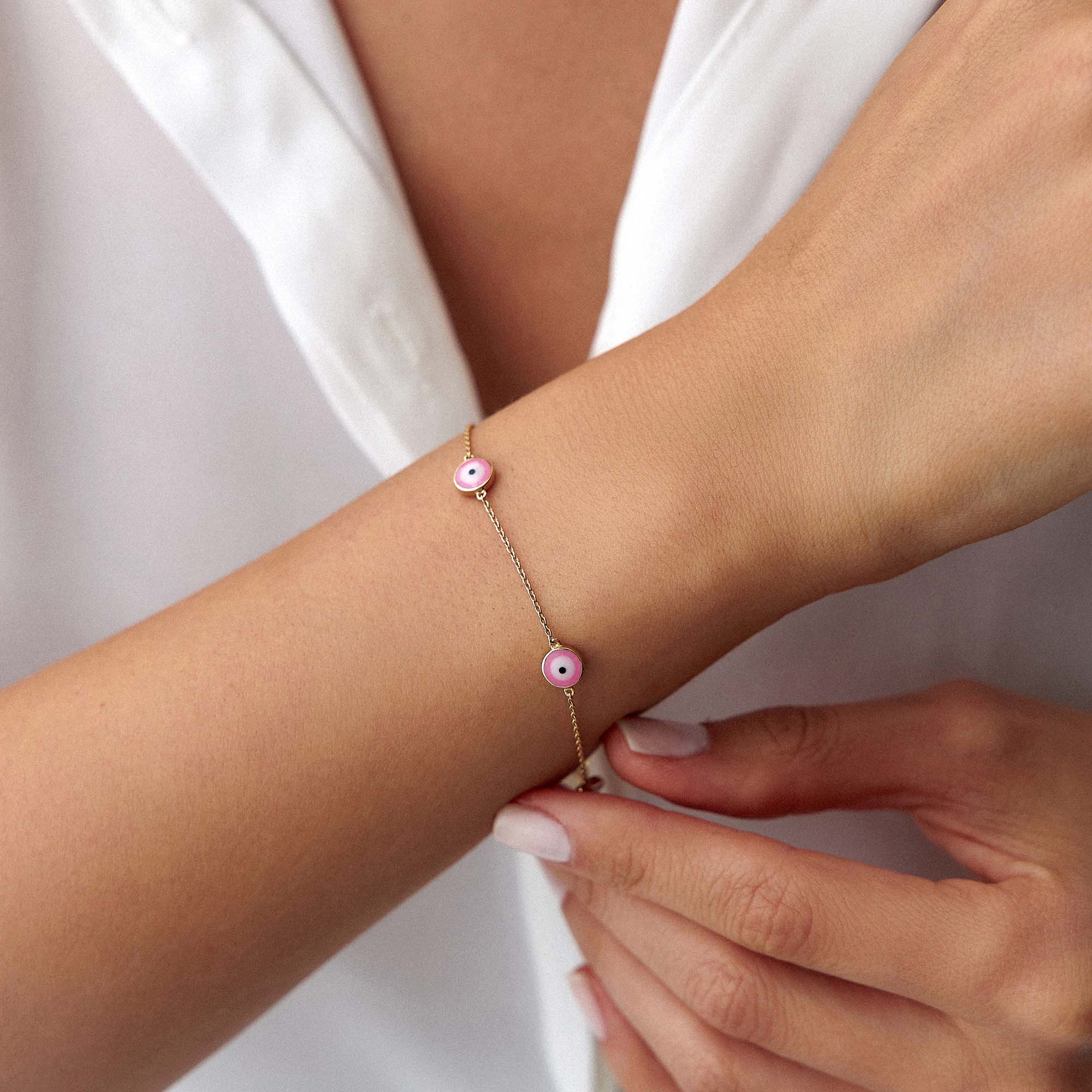 14k yellow gold evil eye bracelet with 5 royal pink evil eyes shown on a wrist