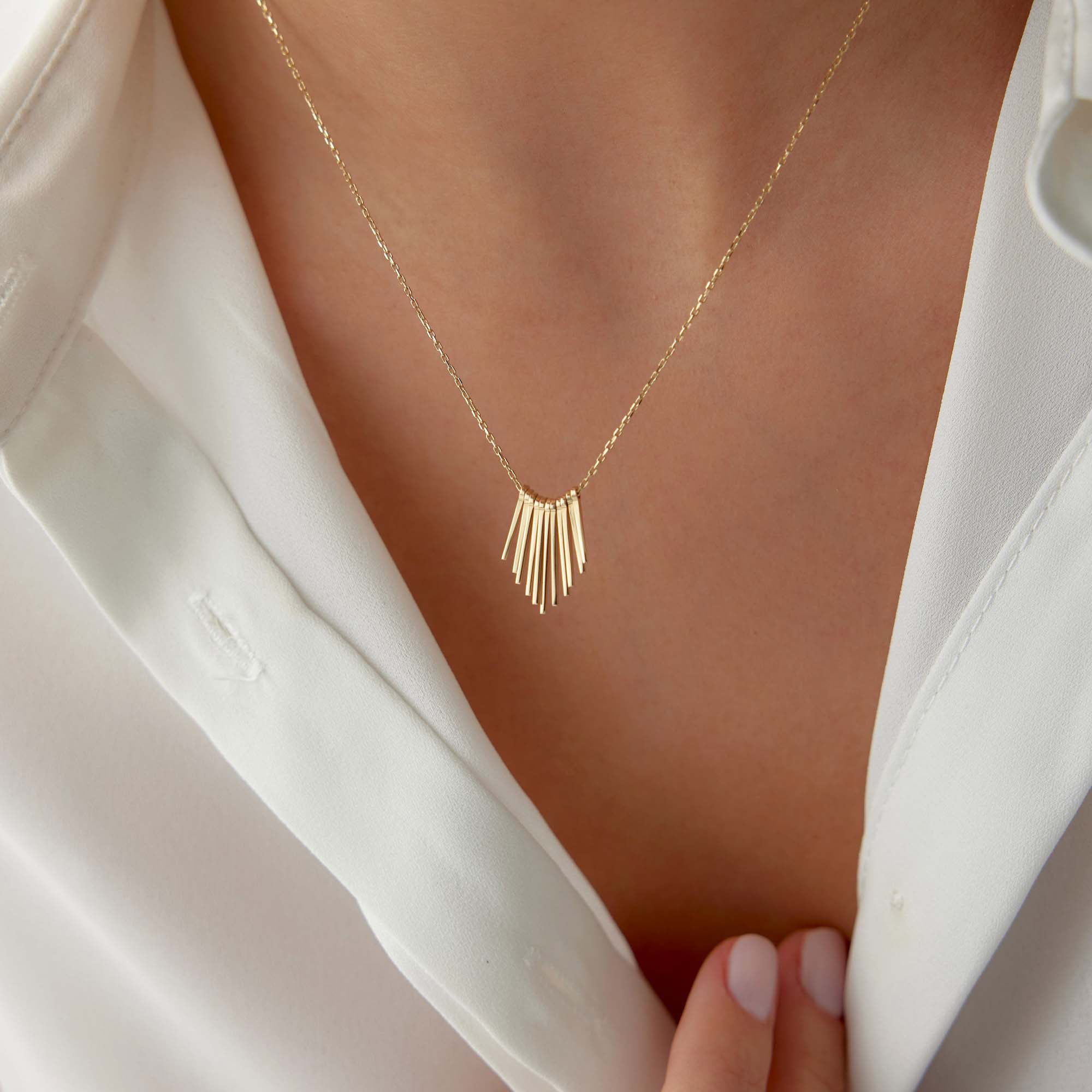 A gold necklace with spike charms together creating the illusion of a sunrise.