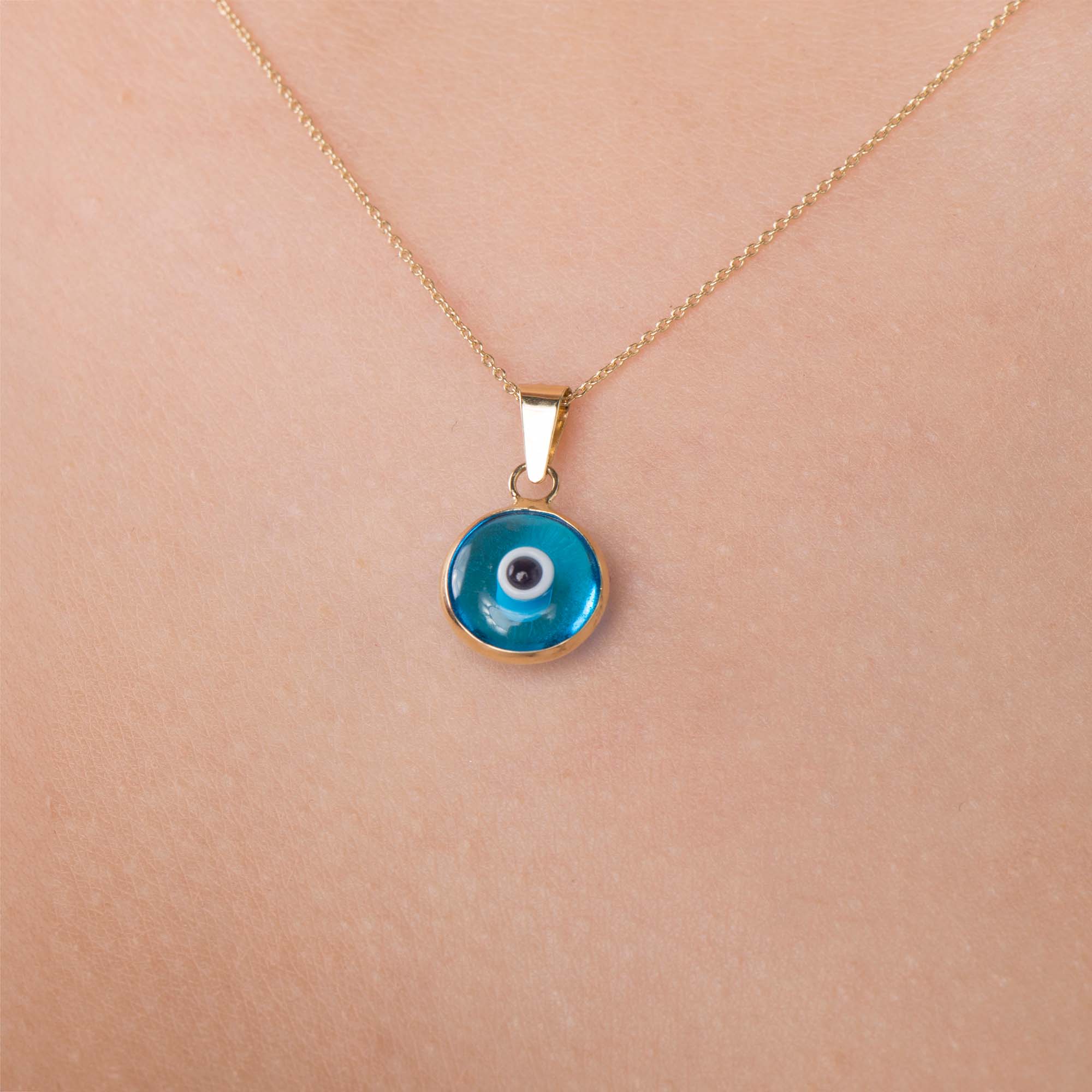 An up-close image of a necklace with a translucent blue evil eye pendant