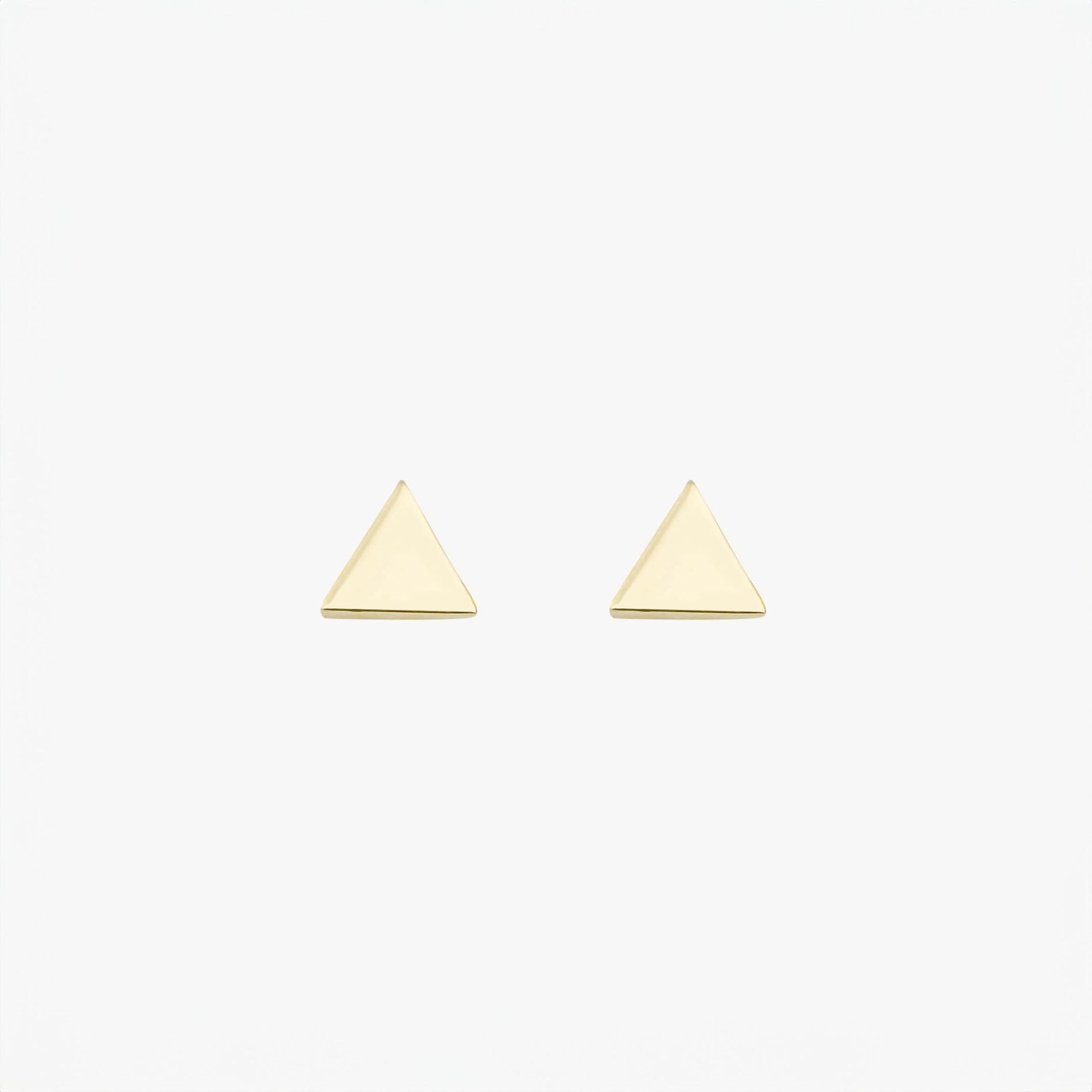 Pair of 14k yellow gold triangle earrings on a white background