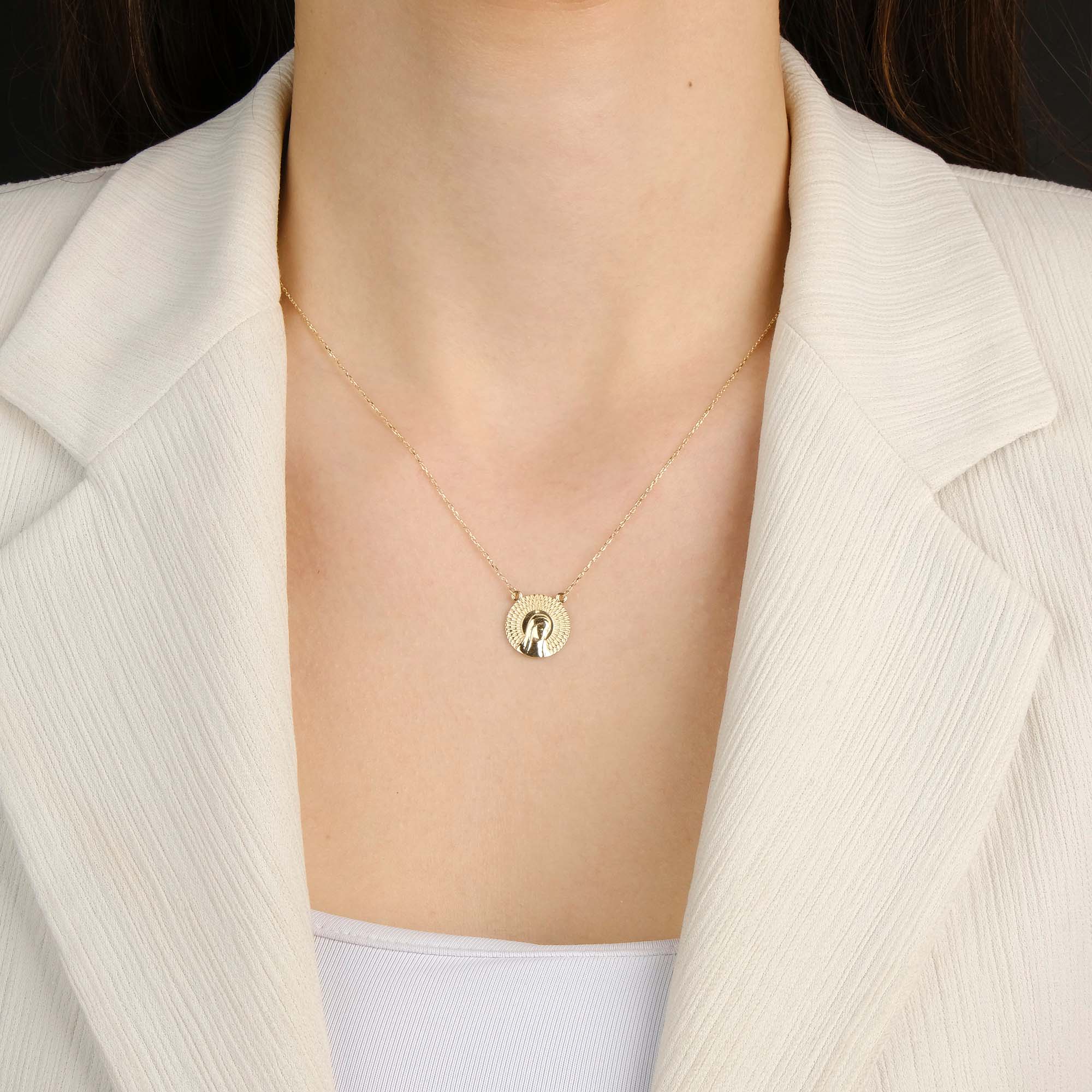 A model wearing a virgin mary necklace