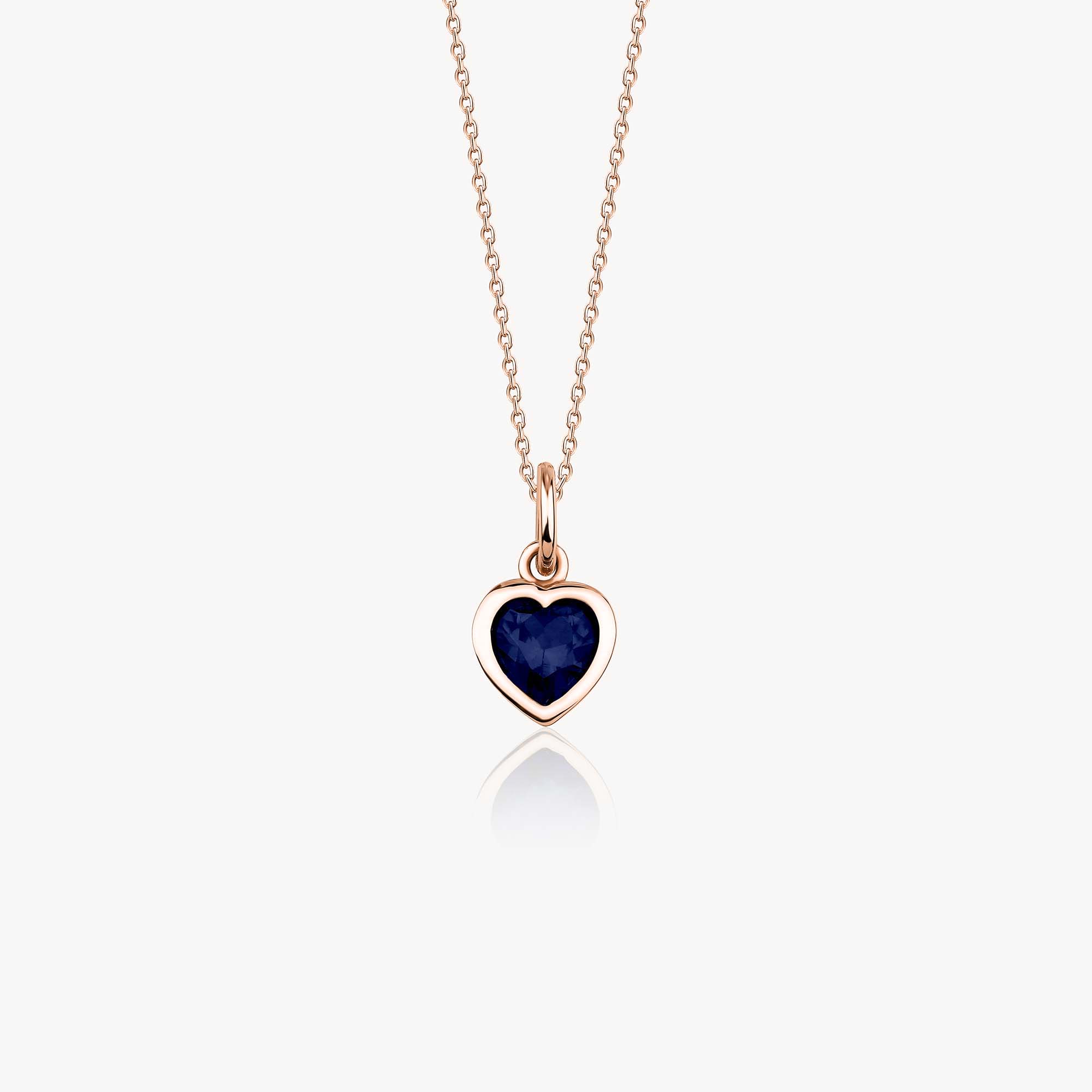 A 14k rose gold necklace with a heart-shaped pendant featuring a blue gemstone on a white background