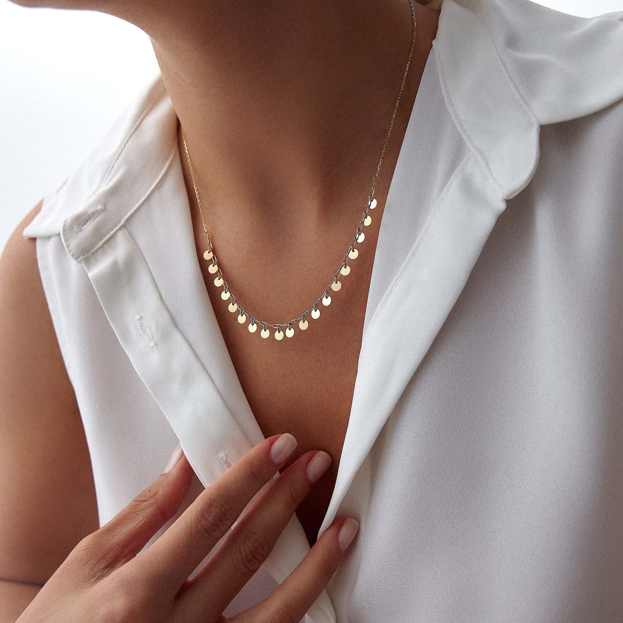 A model wearing a 14k yellow gold disc layering necklace