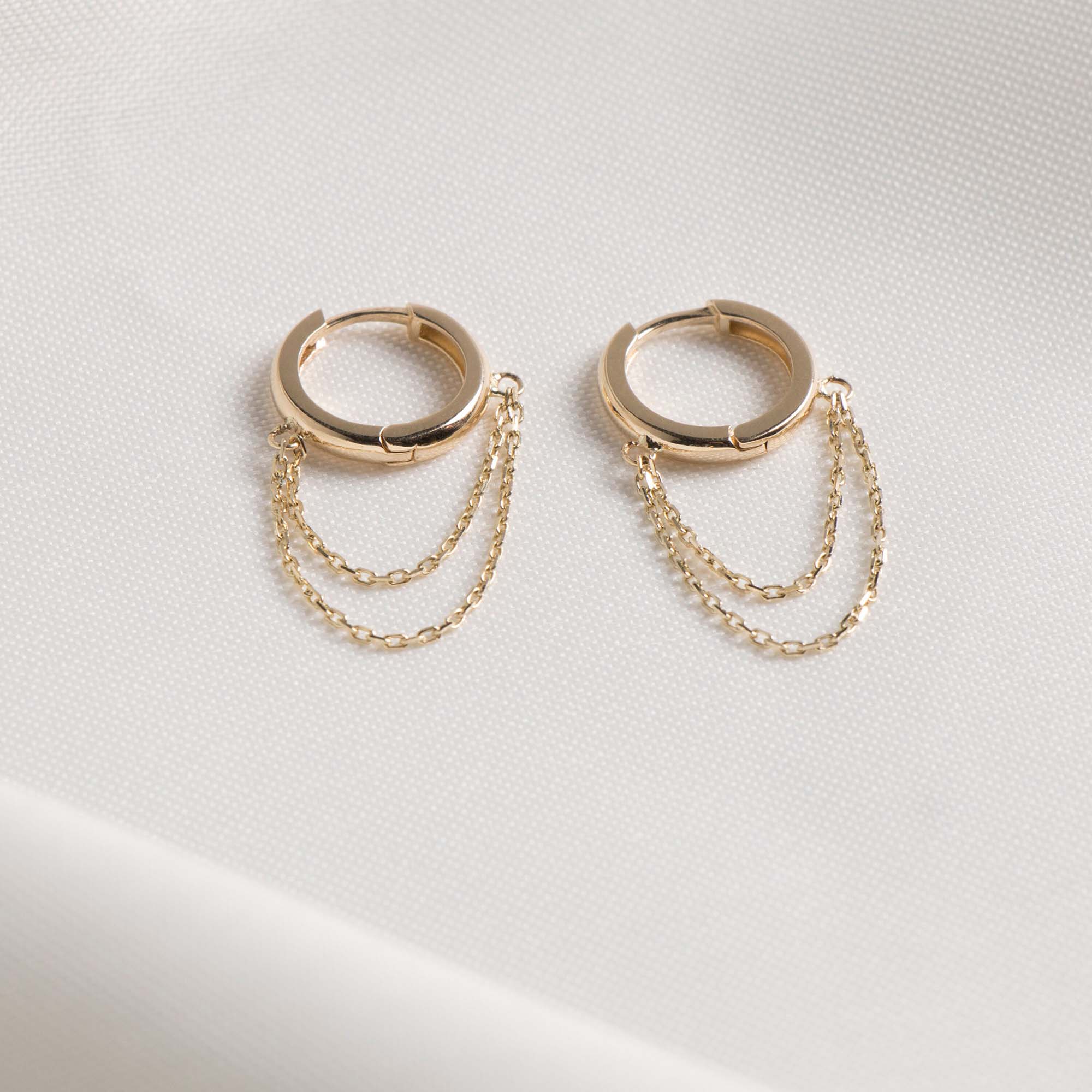 14K Yellow Gold hoop earrings with chain extensions on a light gray background