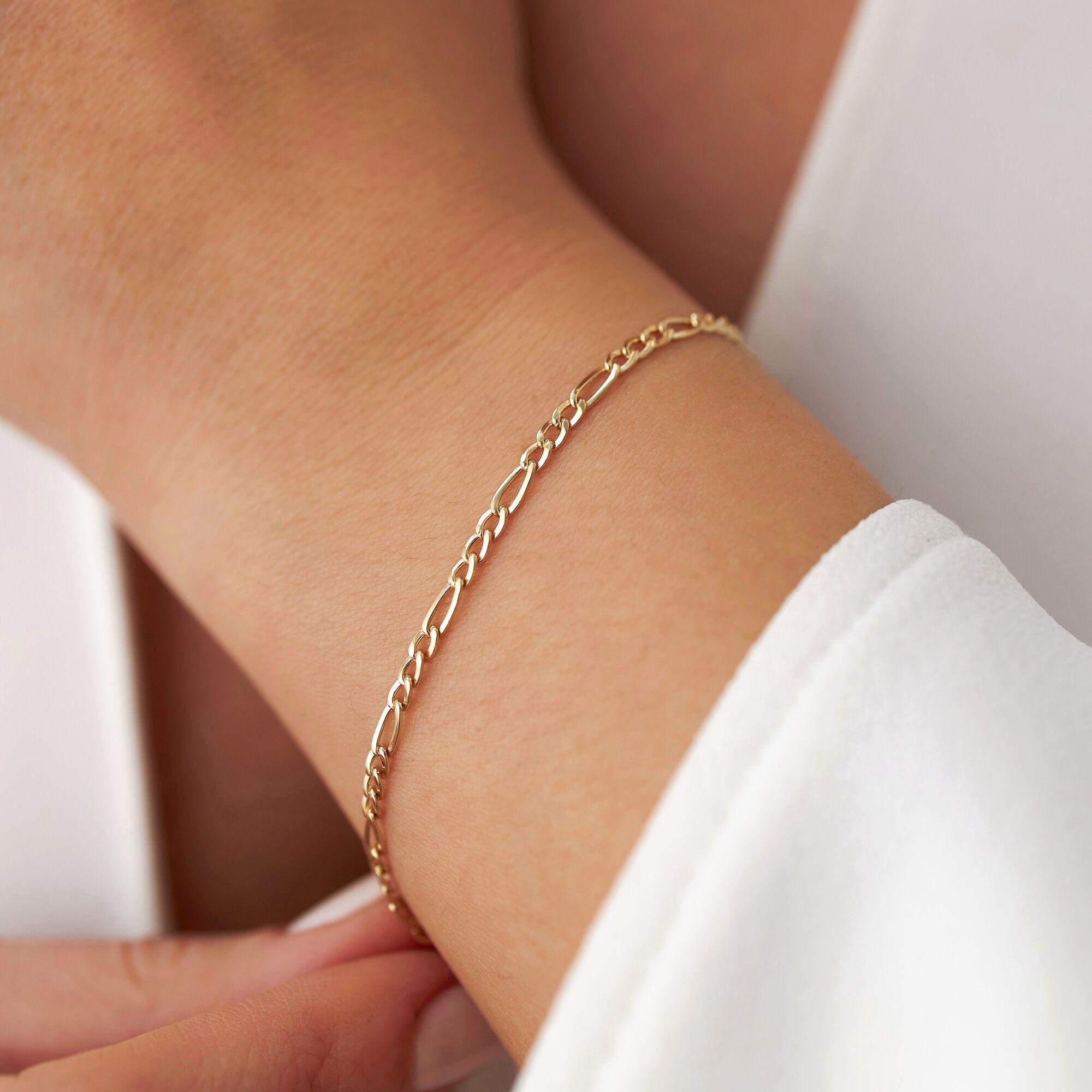 Minimal figaro chain up close on a model's wrist