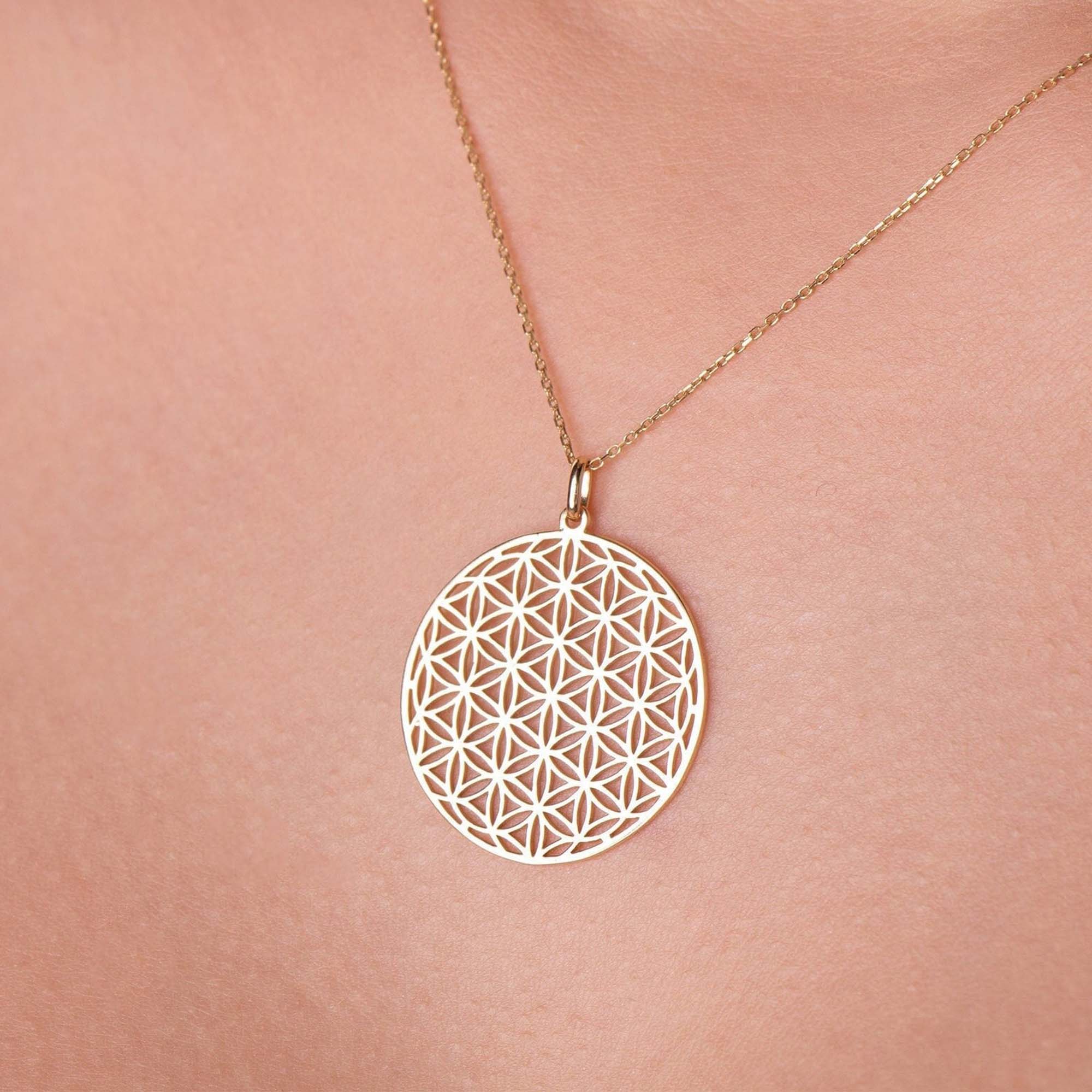 A model wearing a Flower Of Life Pendant on a thin gold chain