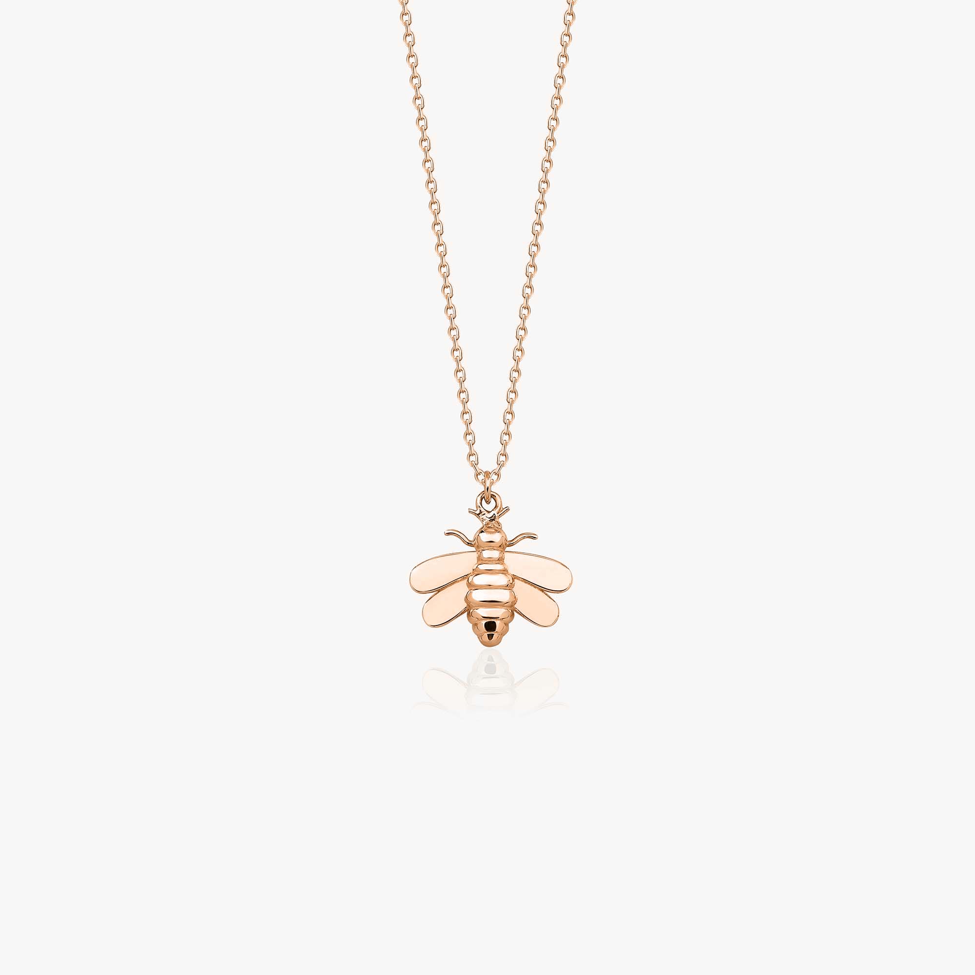 A 14k rose gold bee necklace on a white background