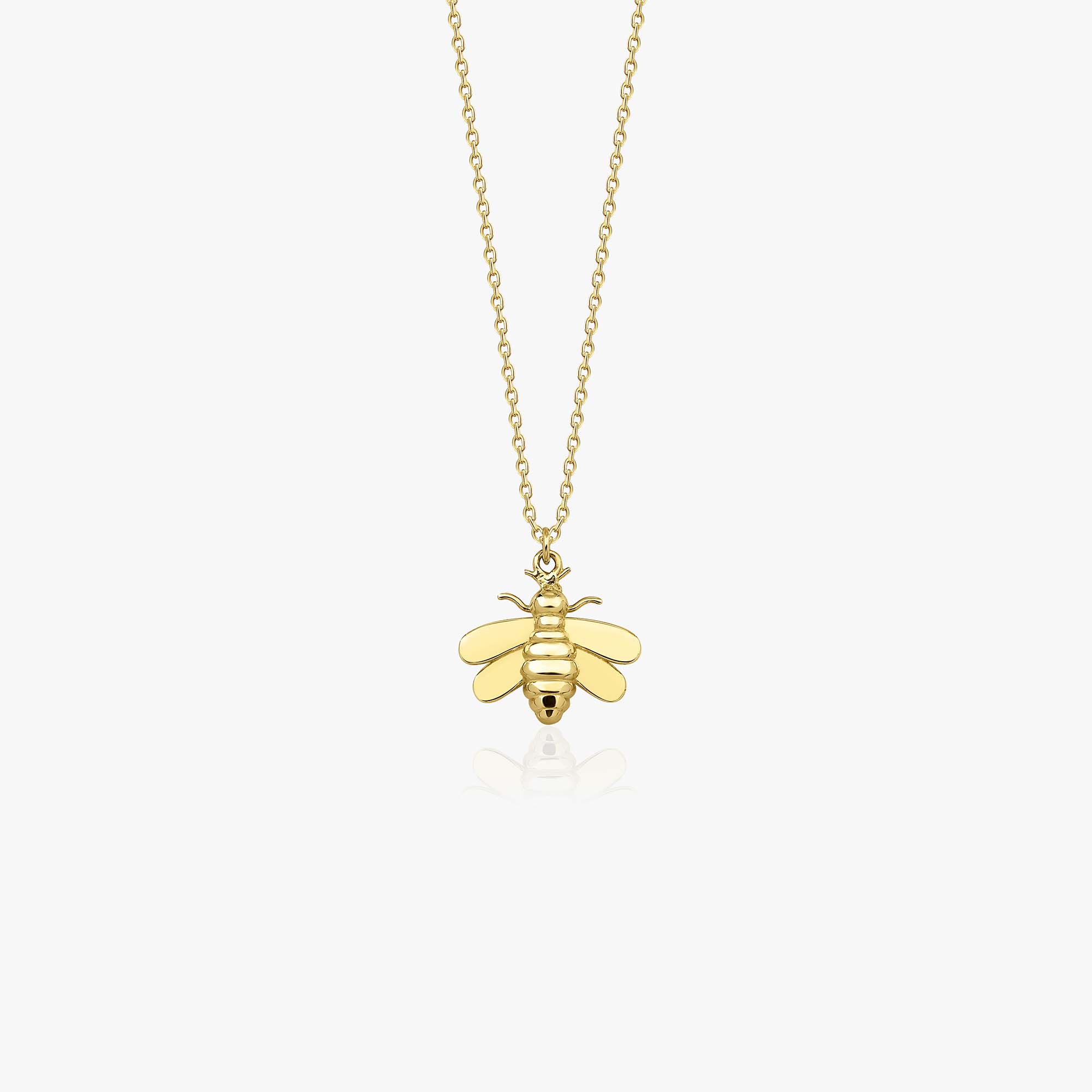 A 14k yellow gold bee necklace on a white background