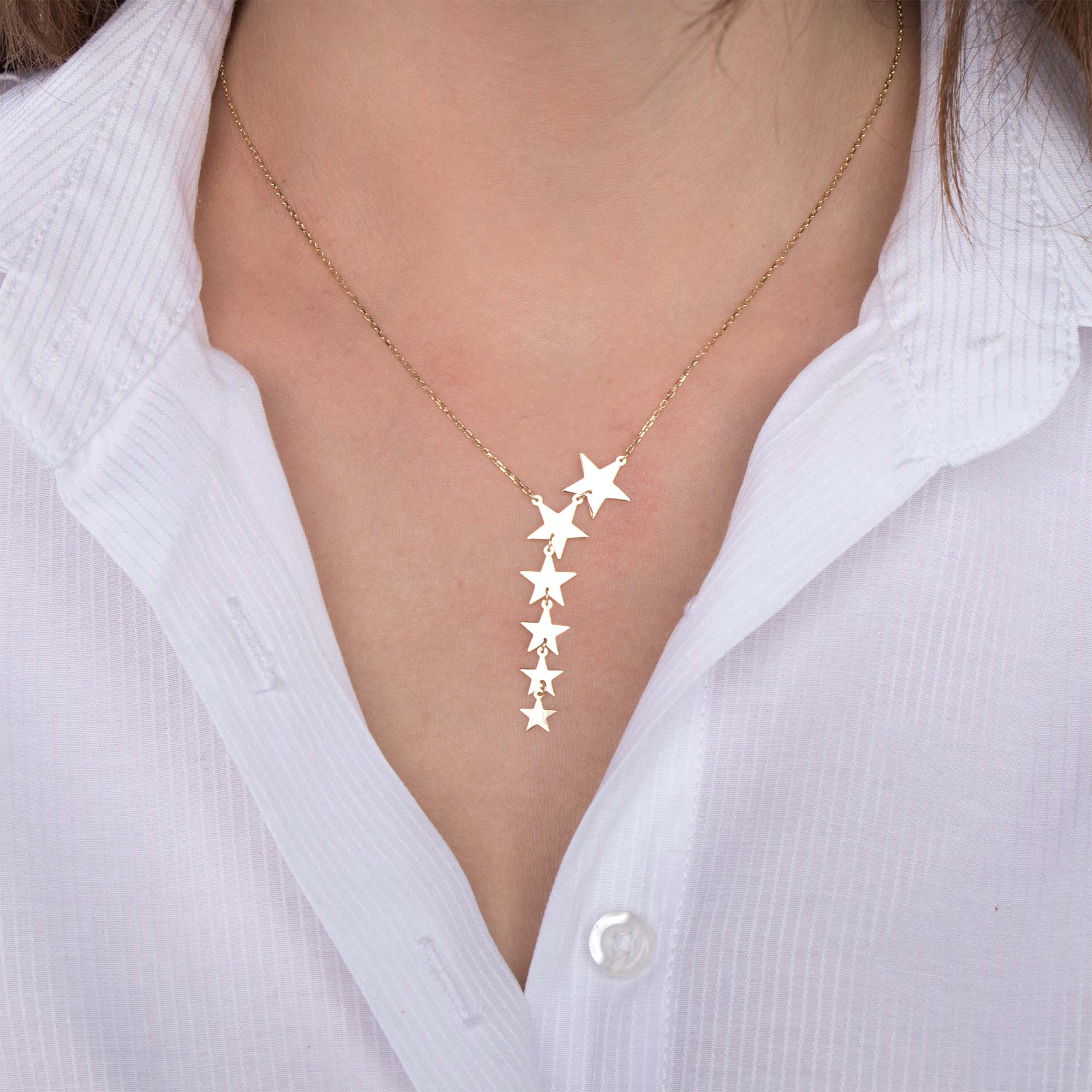 A model wearing a graduated star lariat necklace shown up close.