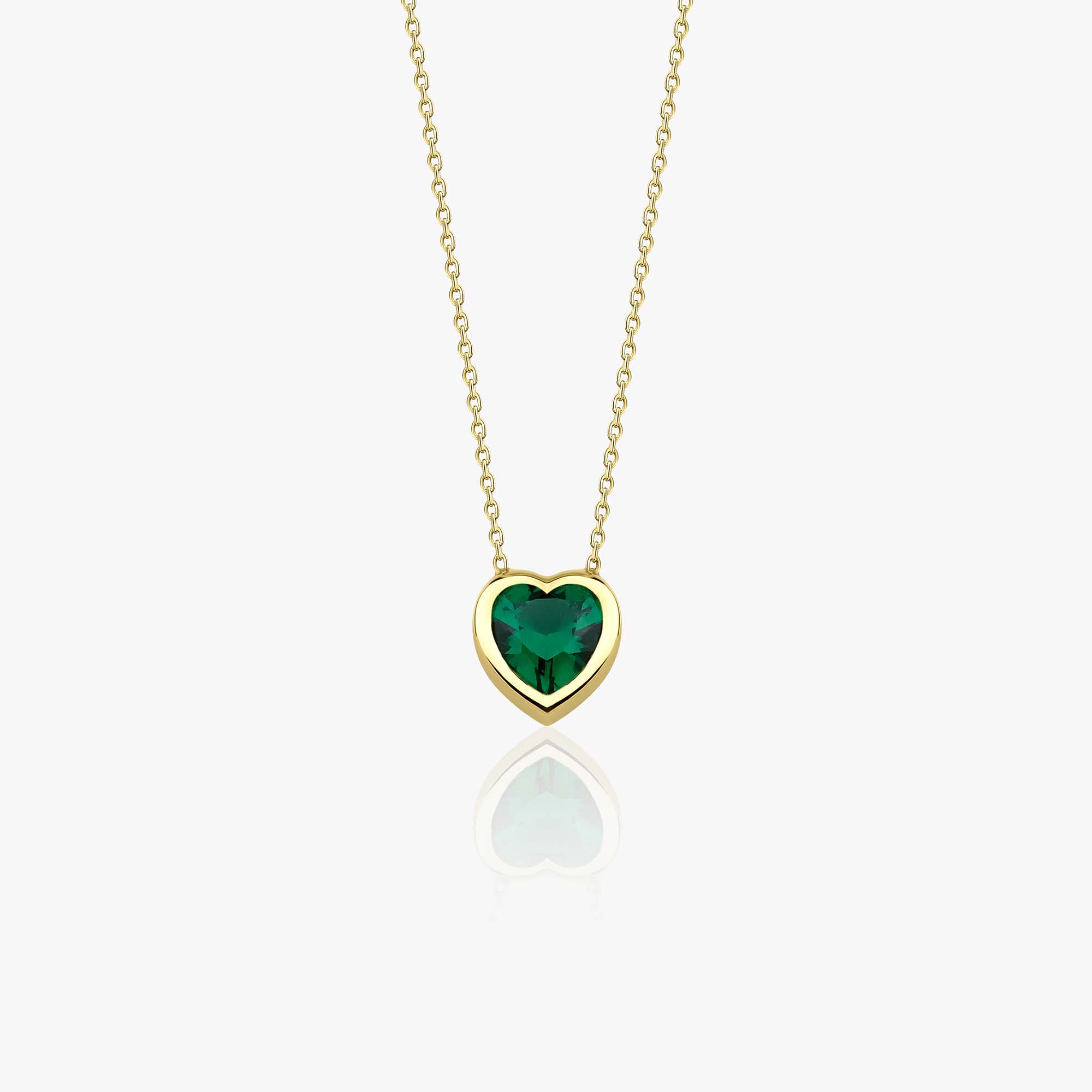 A 14k yellow gold heart-shaped necklace with a green gemstone centerpiece on a white background.