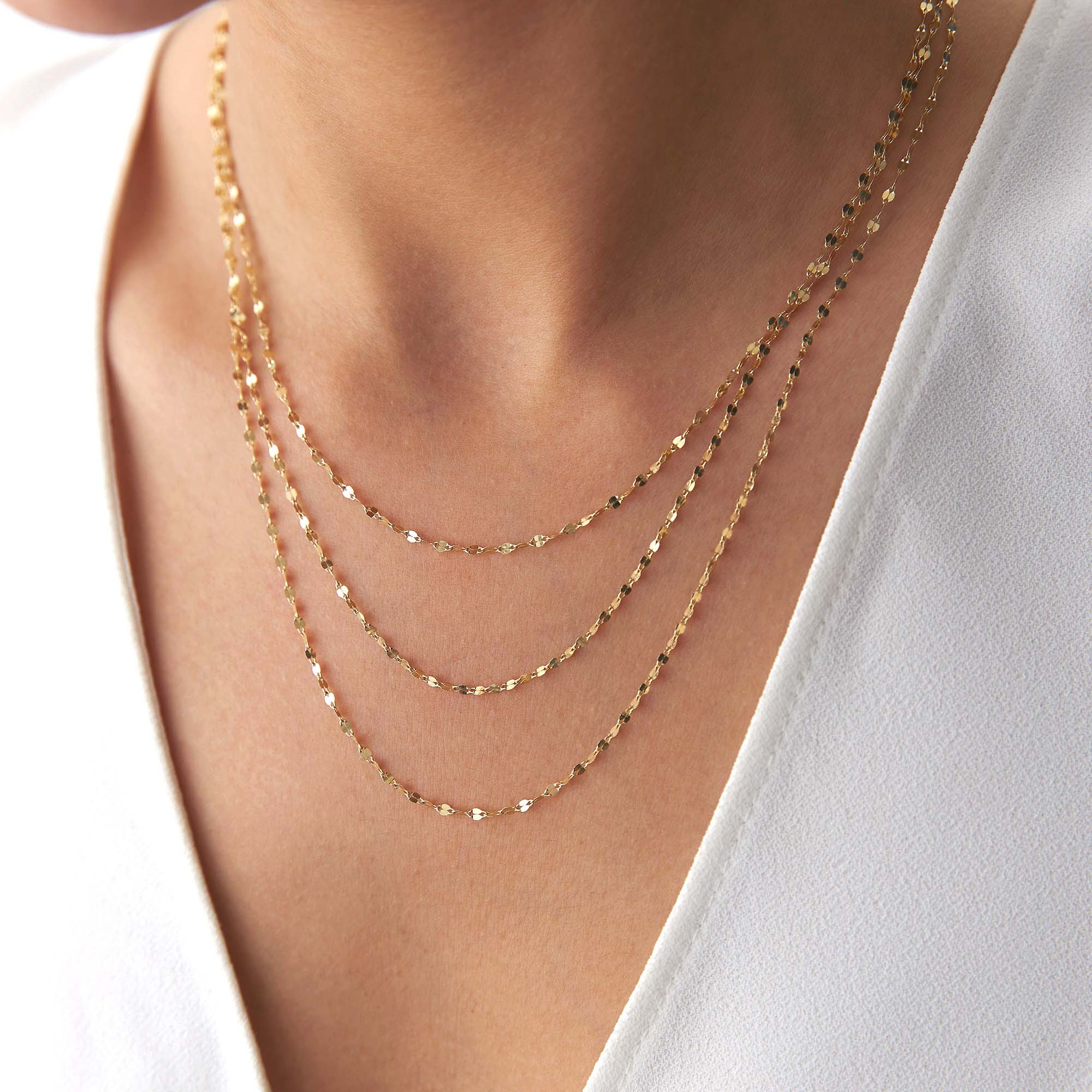 A model wearing three thin italian sparkle chains.