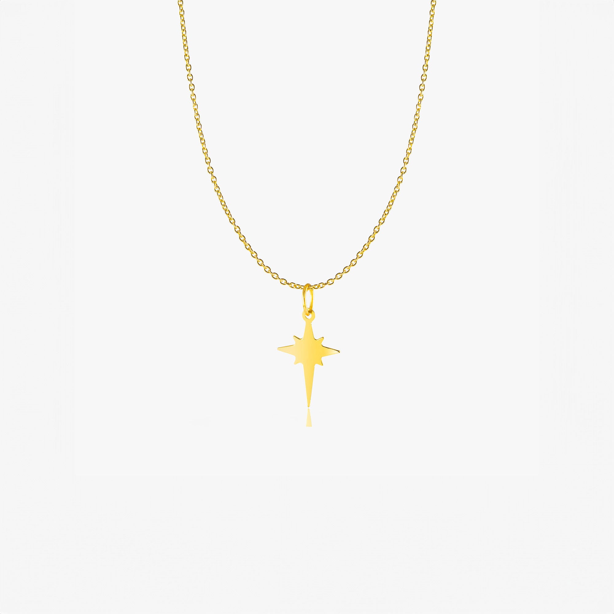 A 14K gold necklace with a plain north star pendant on a chain chain.