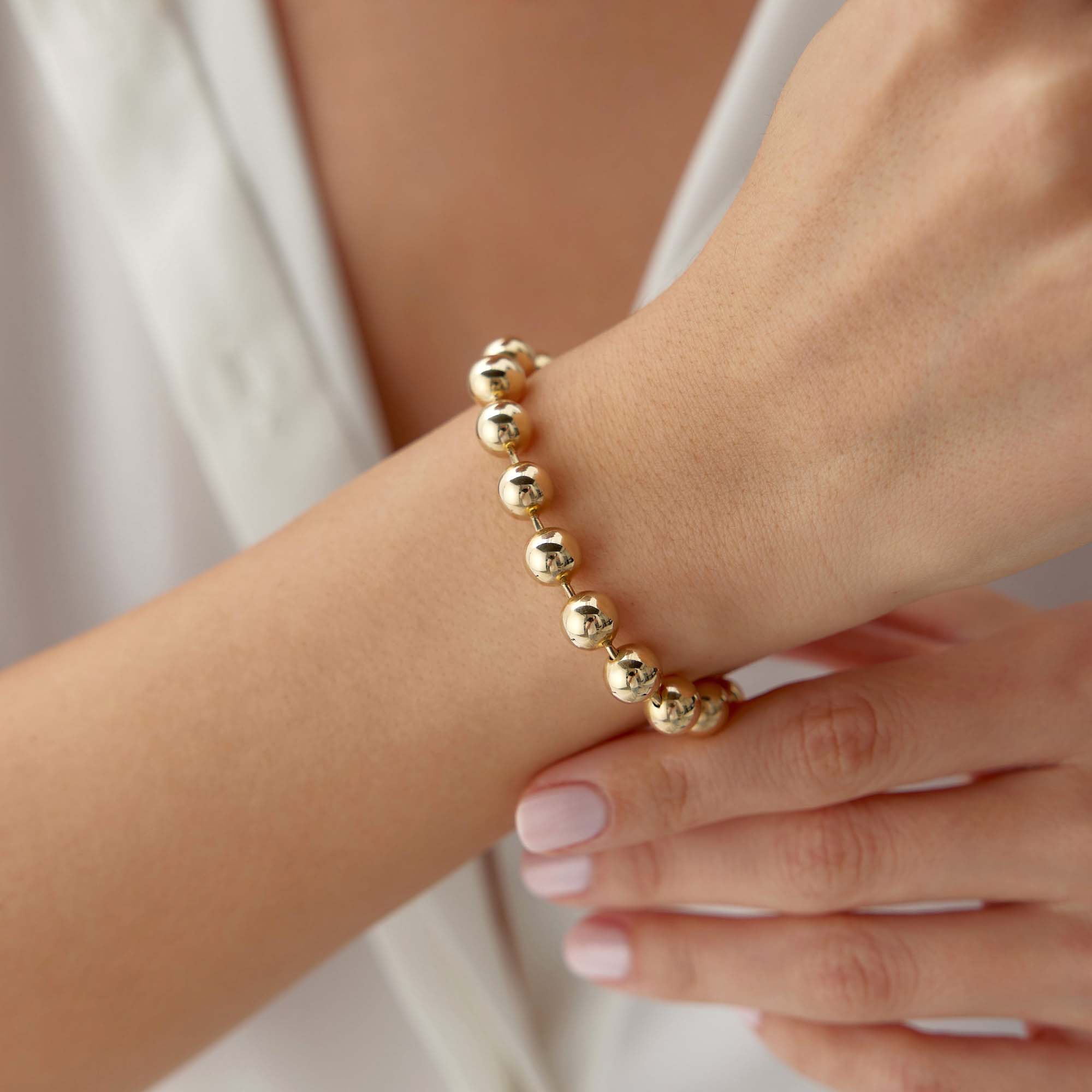 14k yellow gold large beaded bracelet shown in a wrist