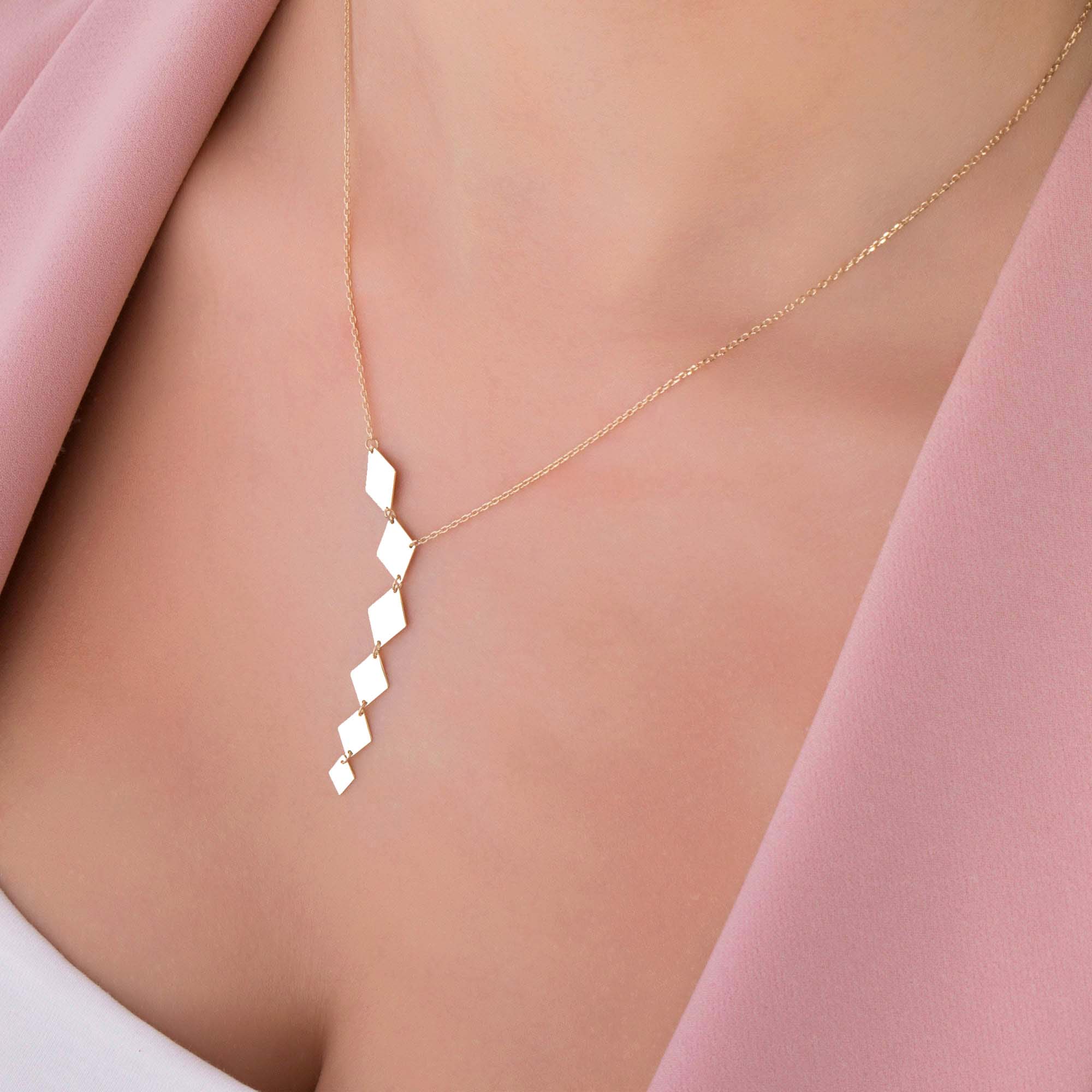 A model wearing a 14k yellow gold lariat necklace.