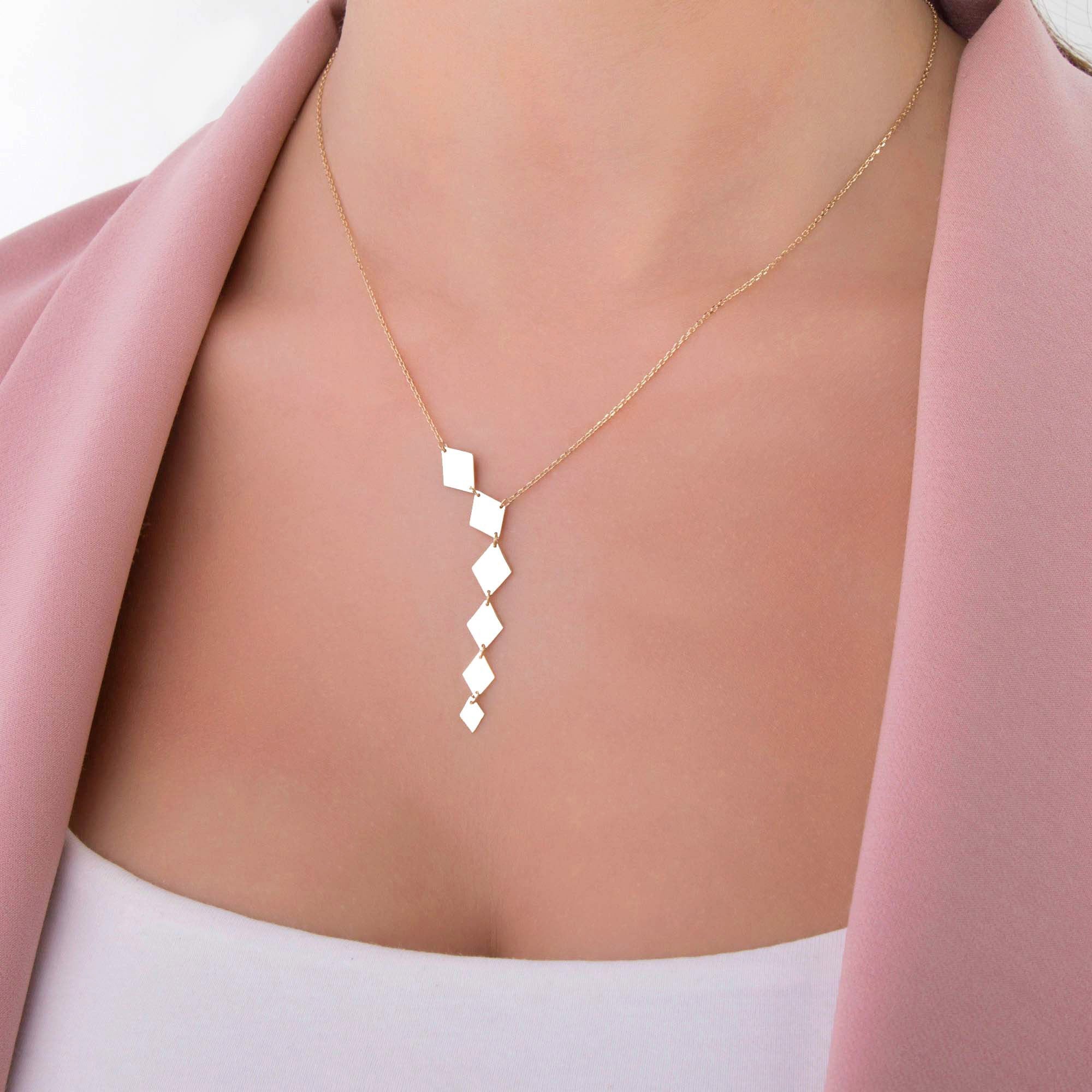 A model wearing a 14k yellow gold lariat necklace.