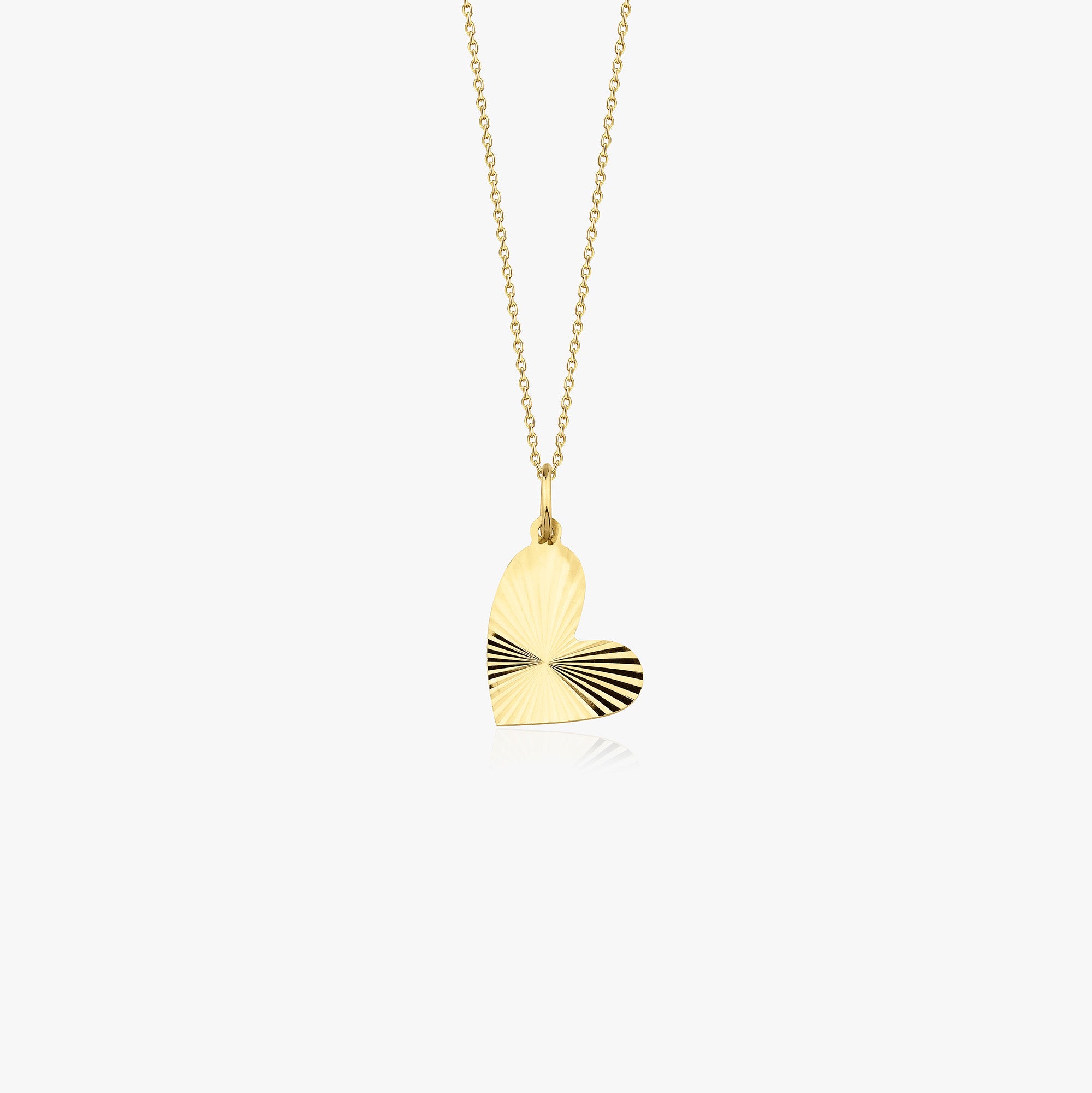 A 14k yellow gold heart pendant necklace with laser cut center to add sparkle shown on a white background