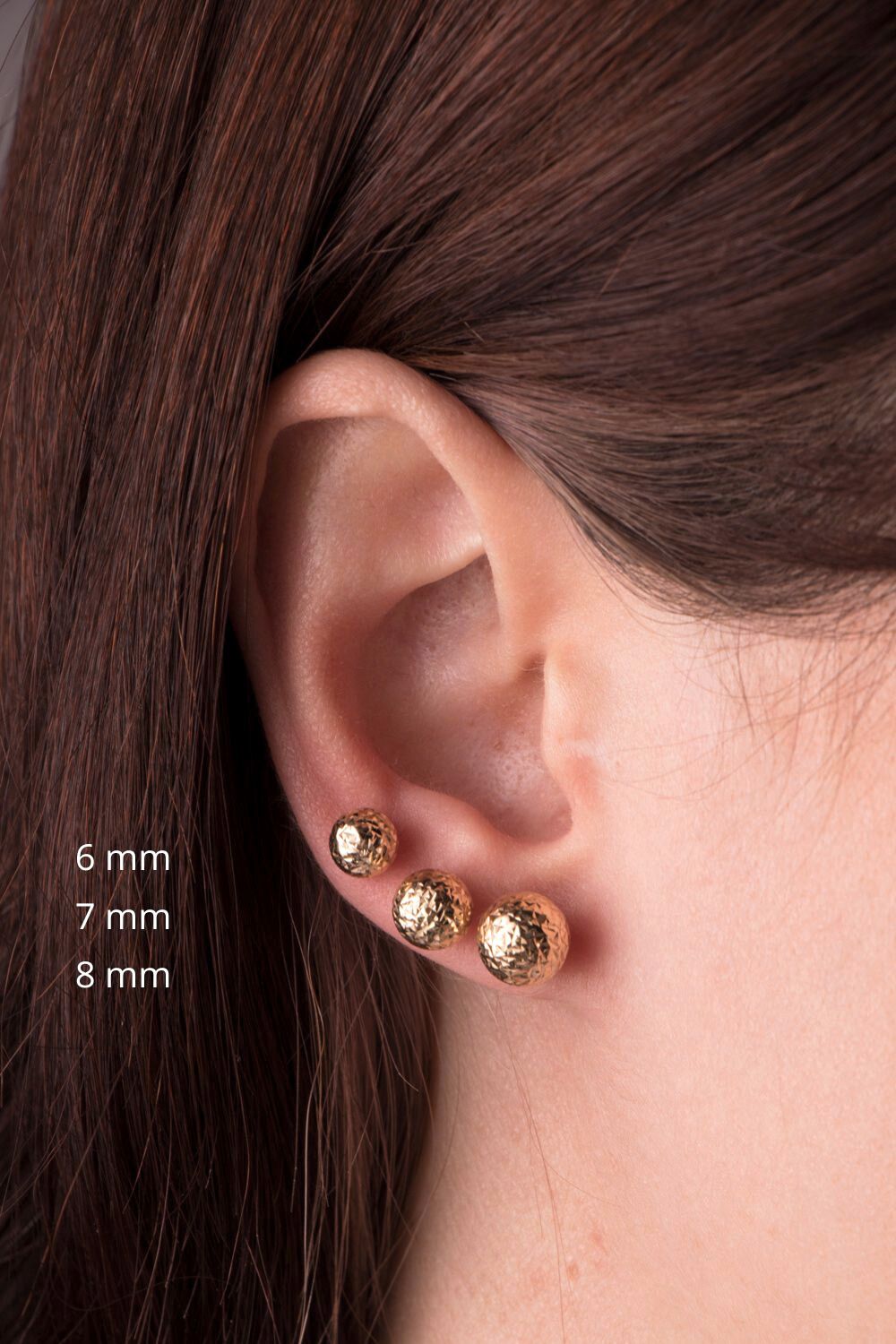 Minimal lazer cut studs shown on a model's ear from 6 mm to 8 mm
