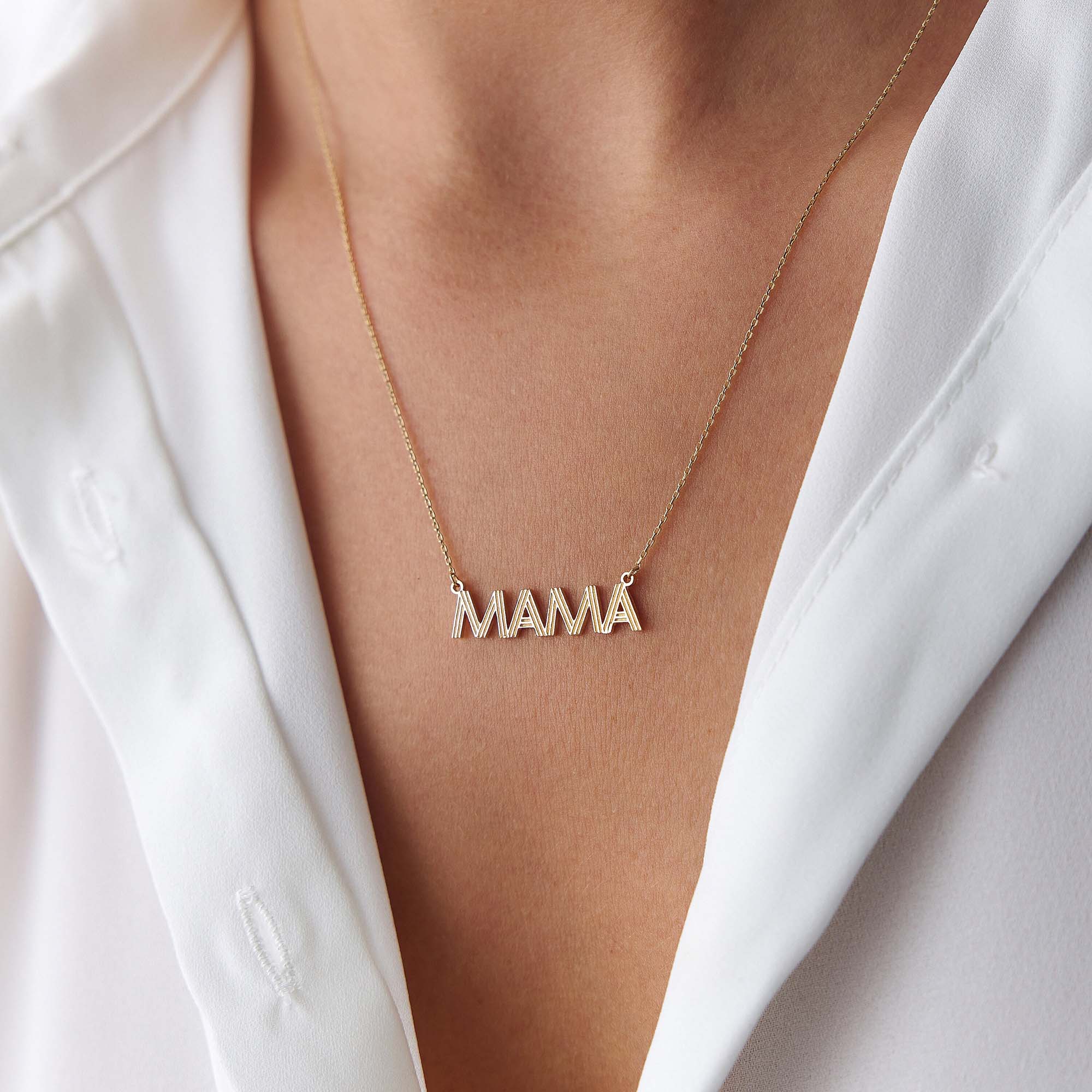 A model wearing a 14k yellow gold mama necklace shown on a model