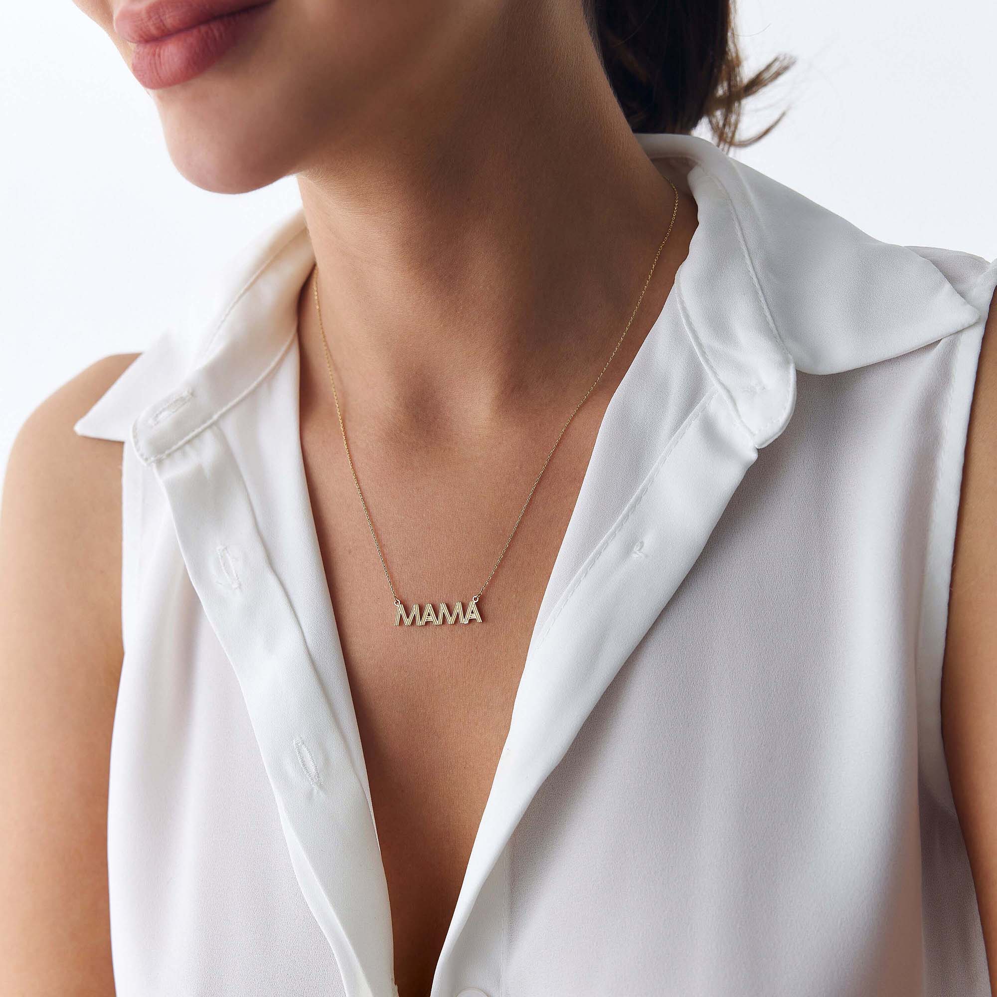 A model wearing a 14k yellow gold mama necklace shown on a model
